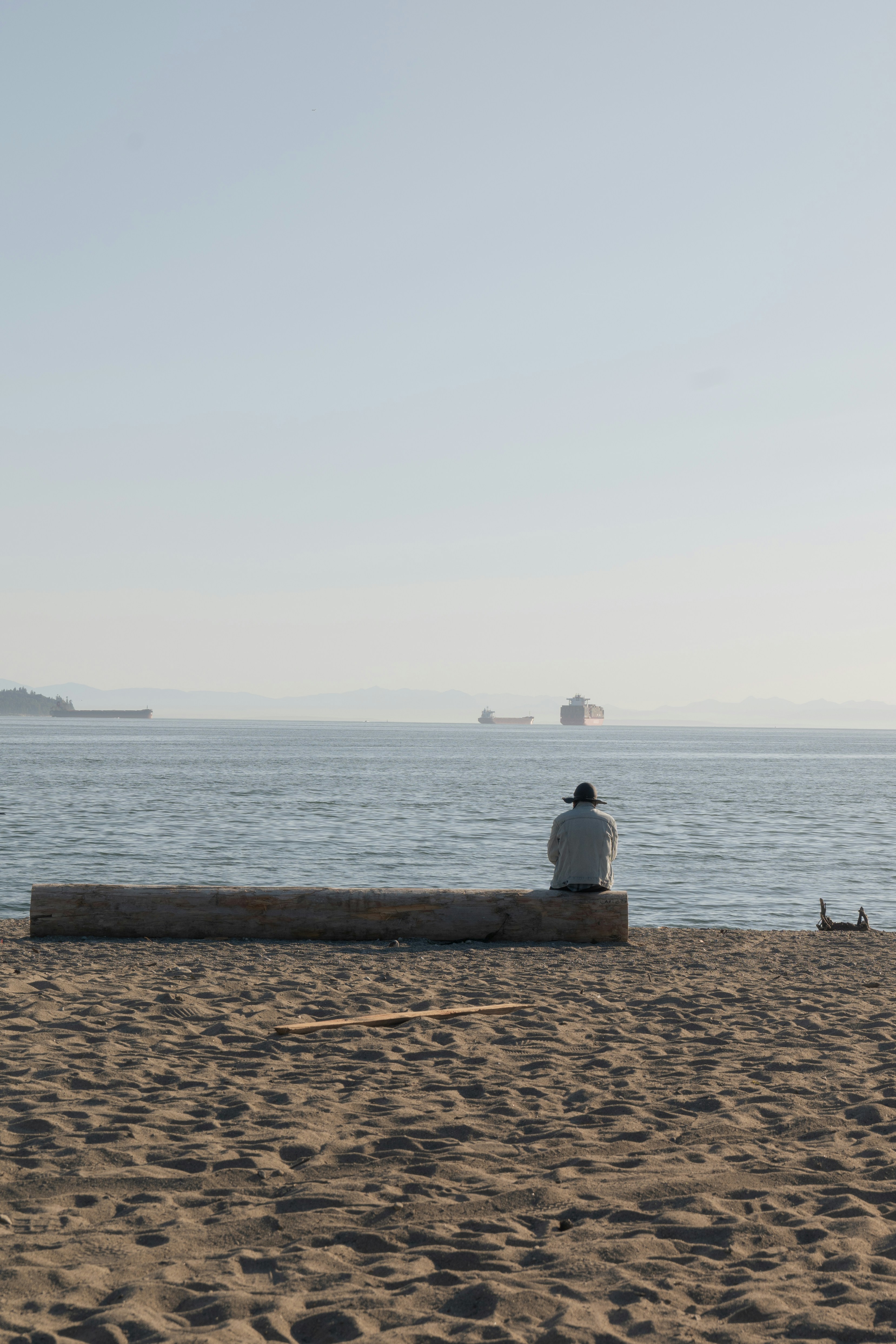 A person sitting on a bench on a beach