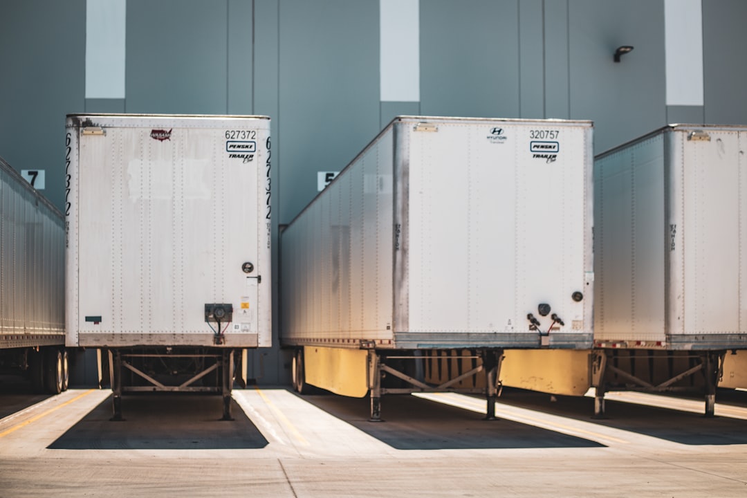 A row of semi trucks parked next to each other,