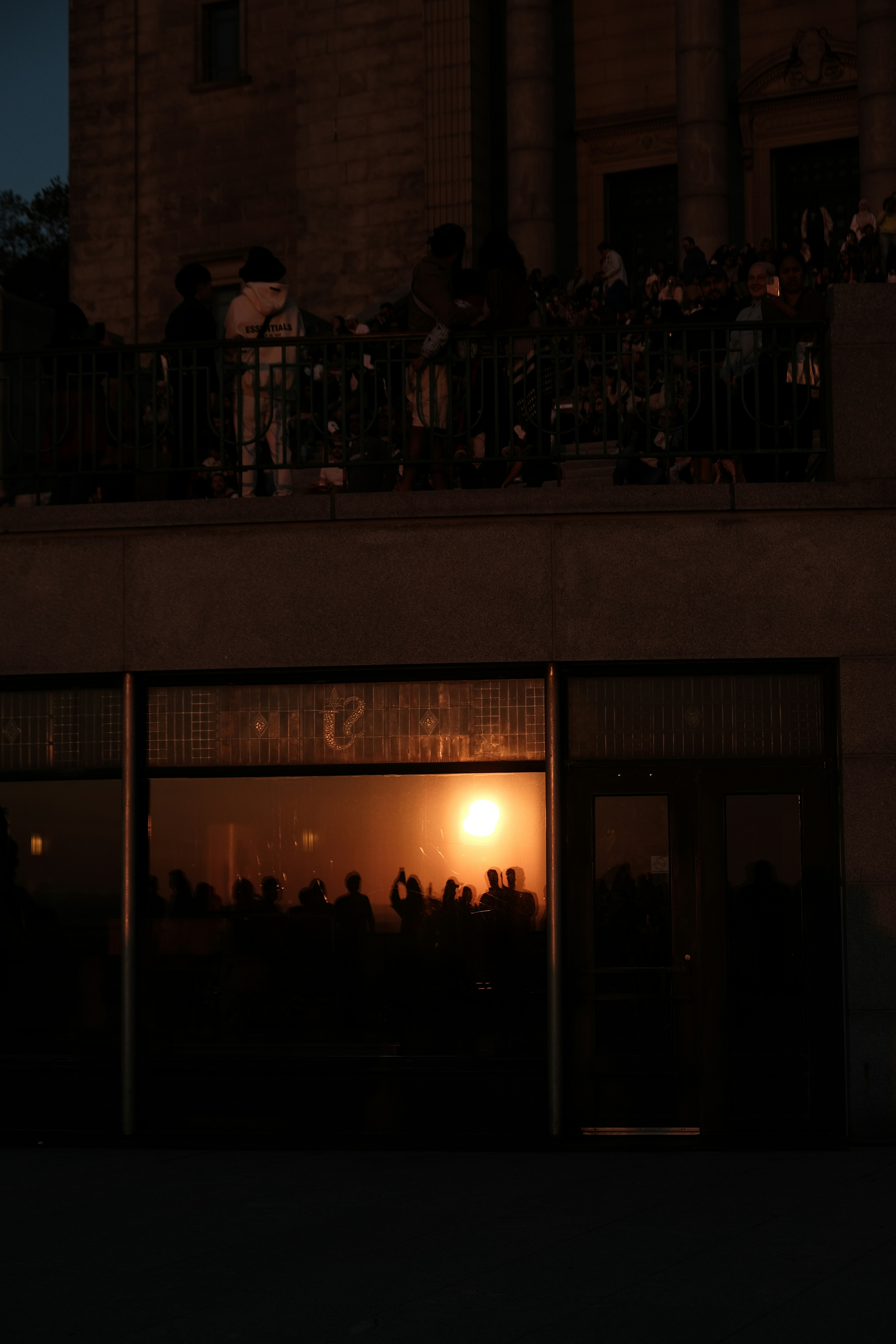 A group of people standing outside of a building at night