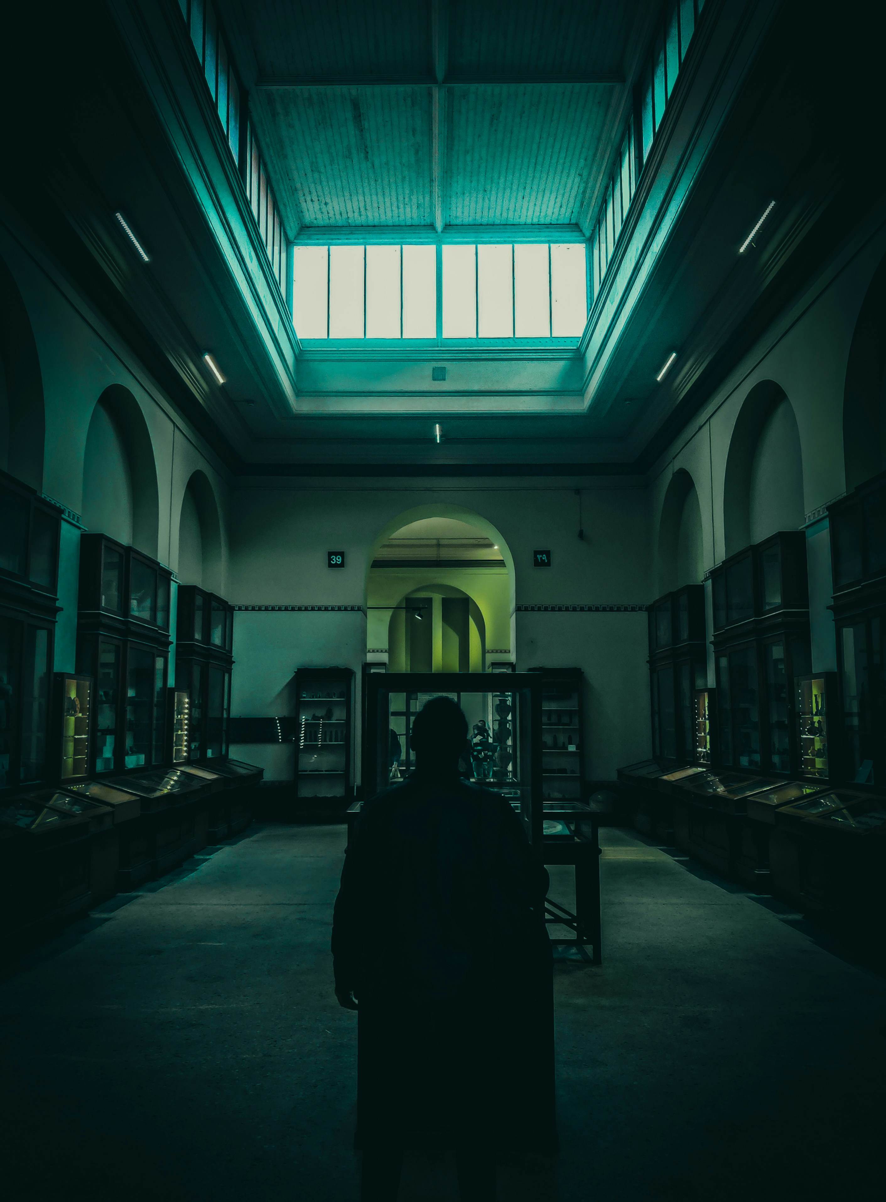 天窓のある暗い部屋に立つ人