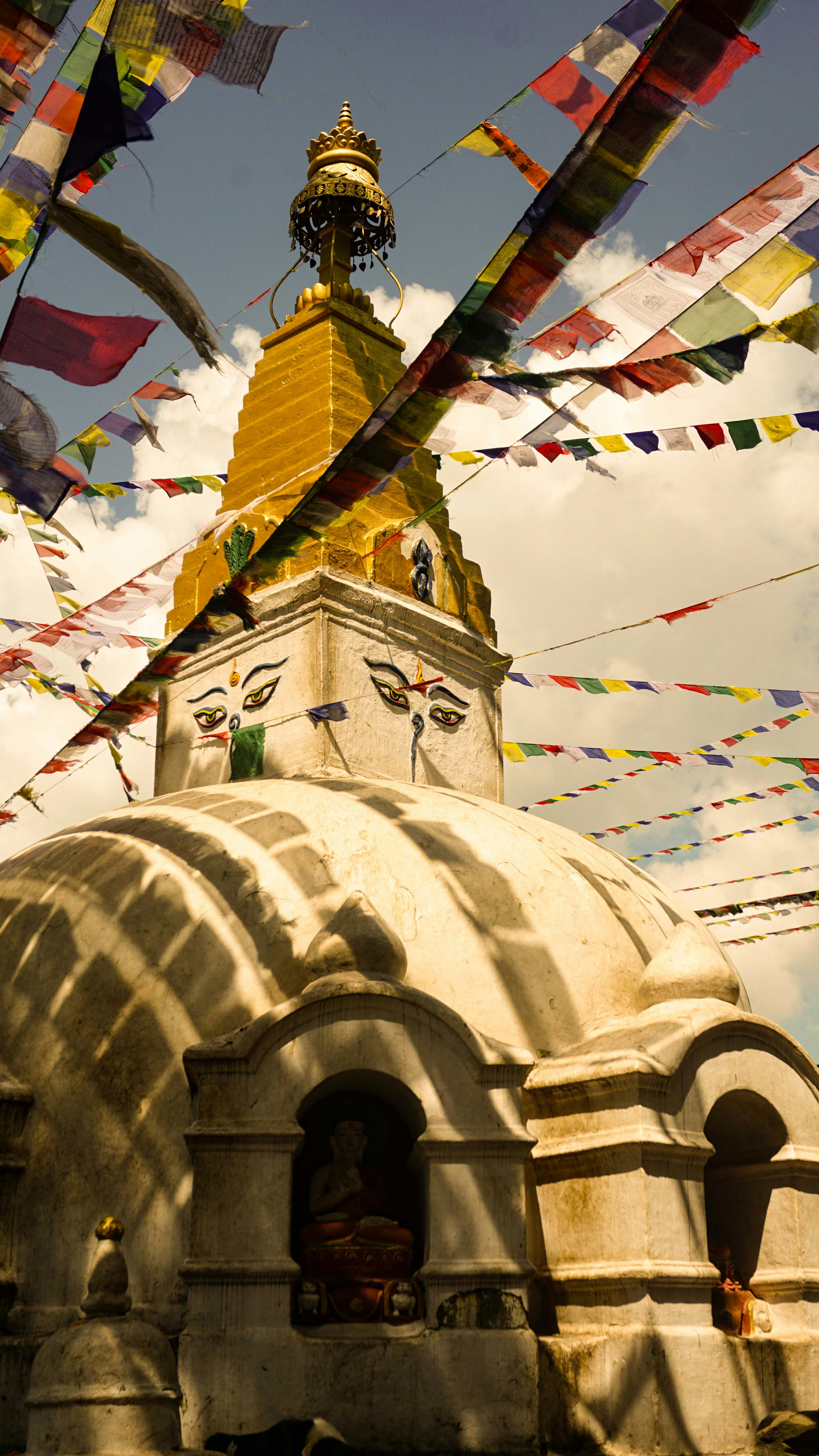 Ein weißes Gebäude mit gelber Spitze, umgeben von bunten Fahnen