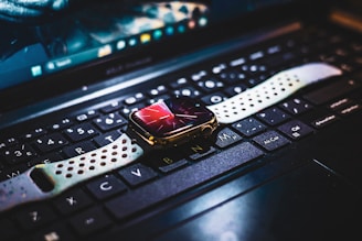 A close up of a computer keyboard with a watch on it