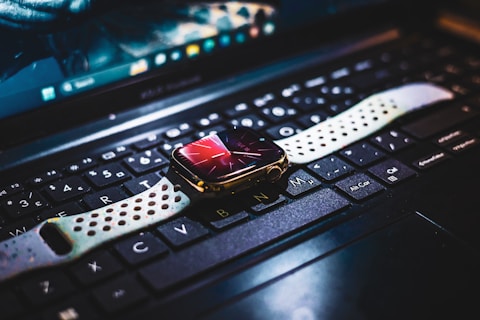 A close up of a computer keyboard with a watch on it