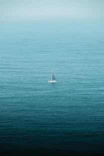 A lone sailboat in the middle of the ocean