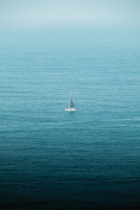 A lone sailboat in the middle of the ocean