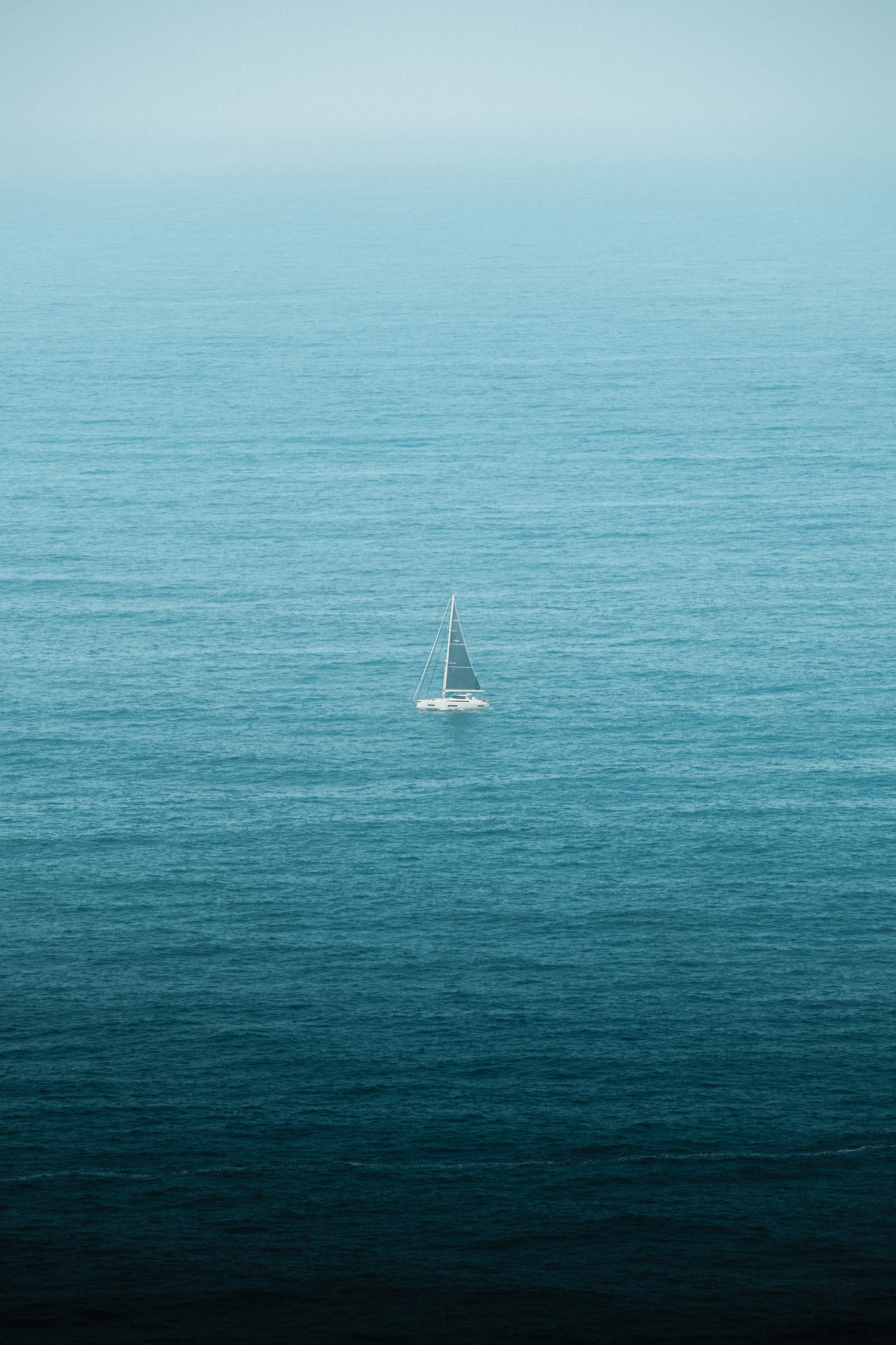 A lone sailboat in the middle of the ocean