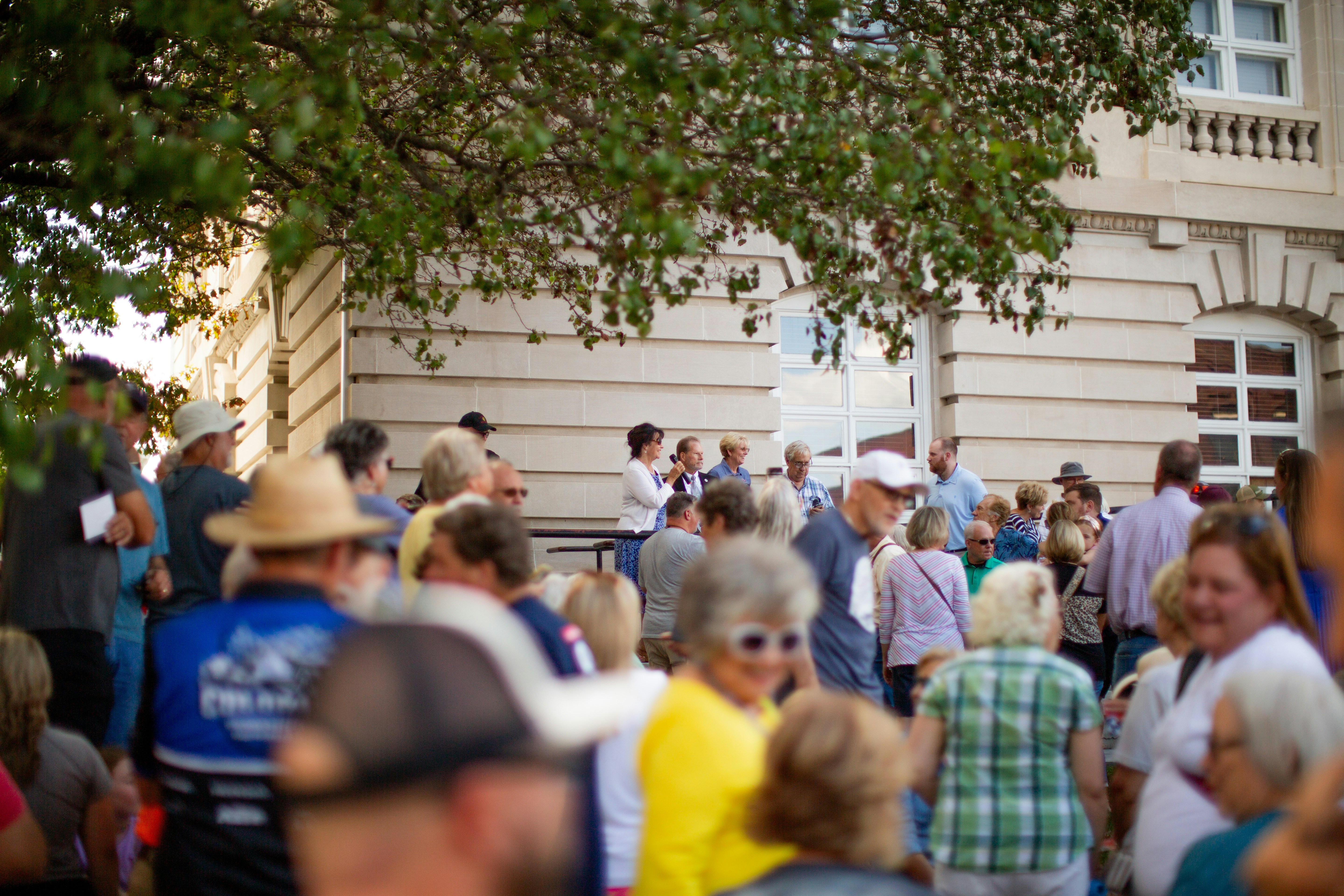 A crowd of people standing around each other in front of a building