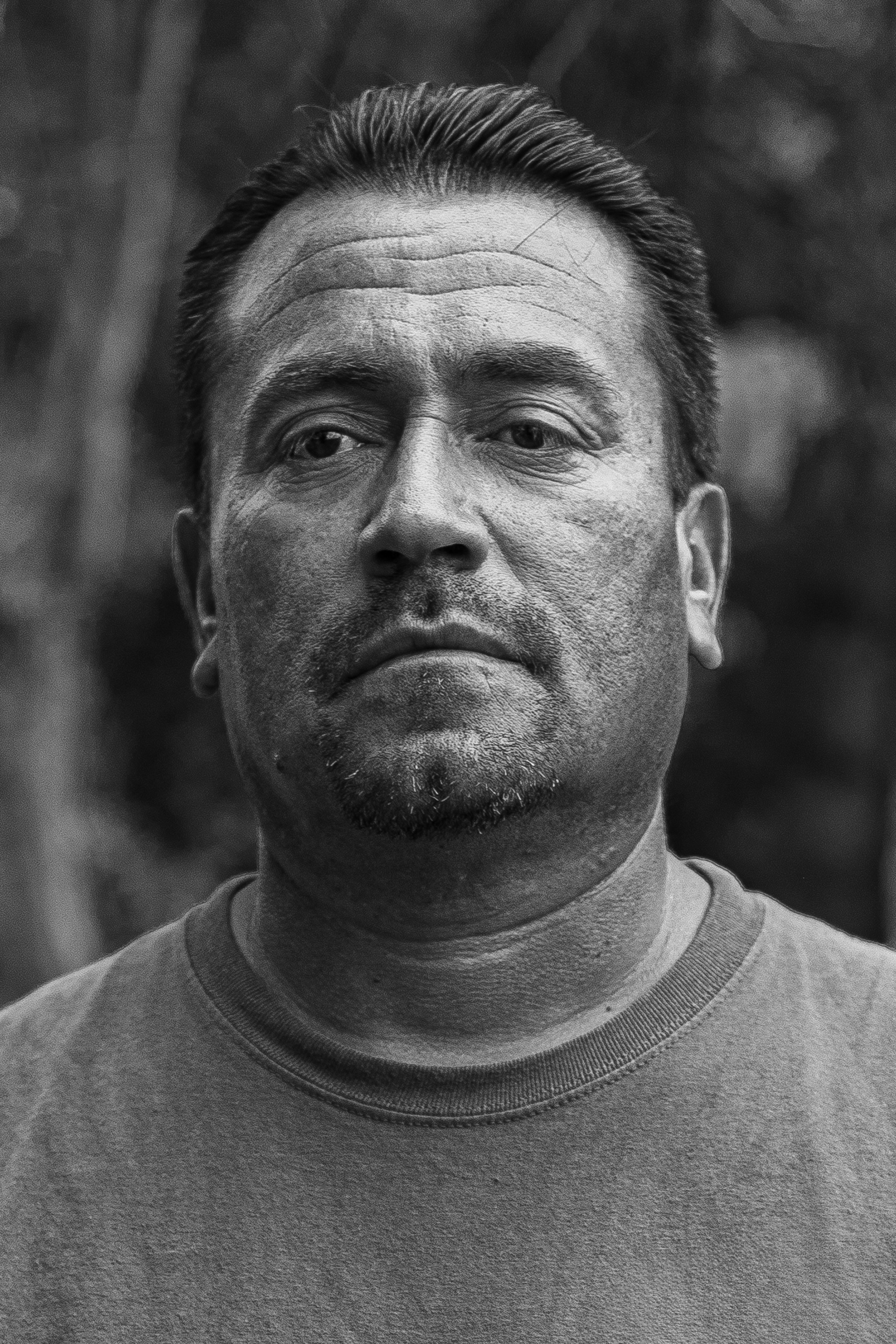 A black and white photo of a man looking at the camera