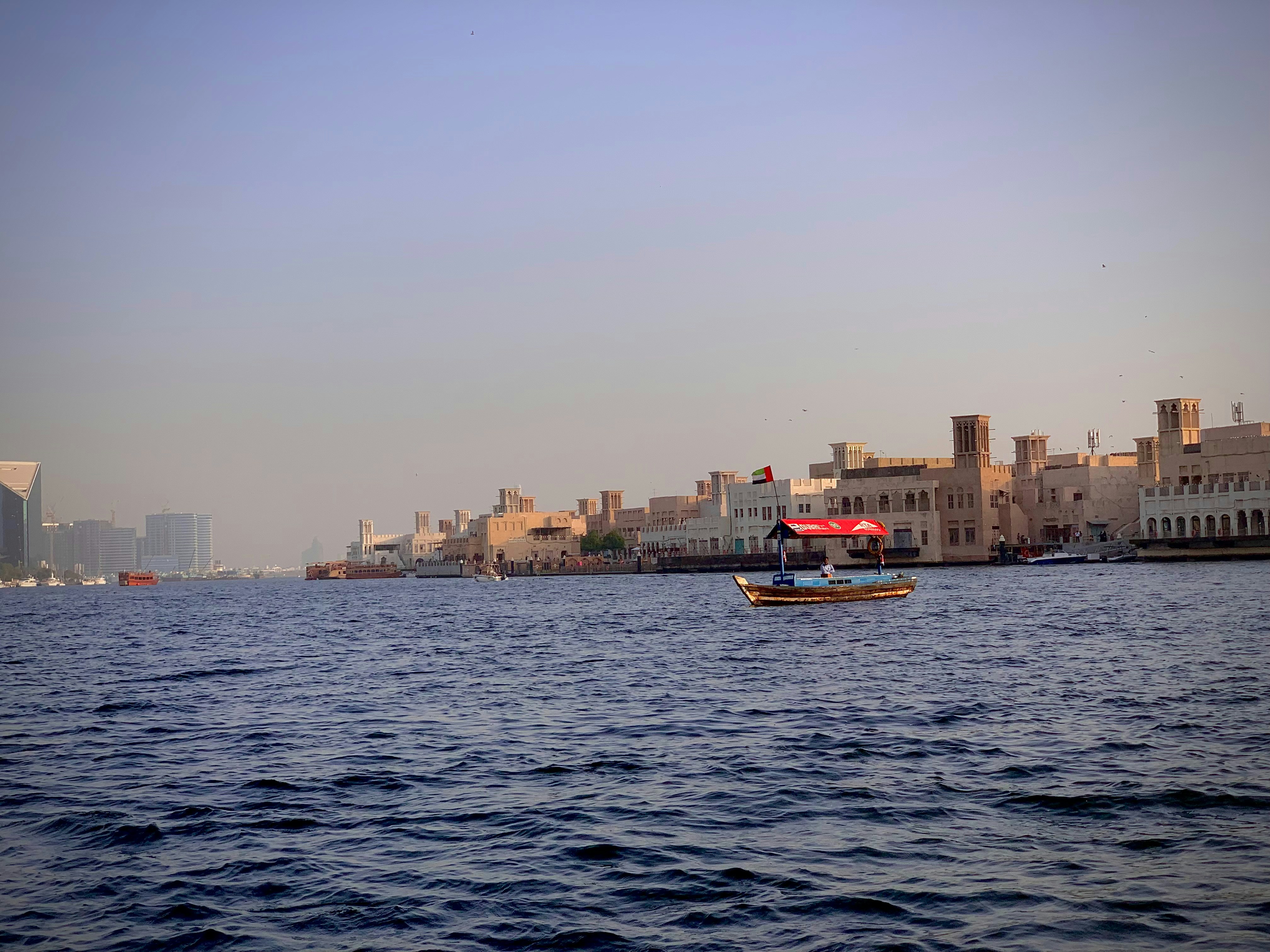 A small boat in the middle of a large body of water