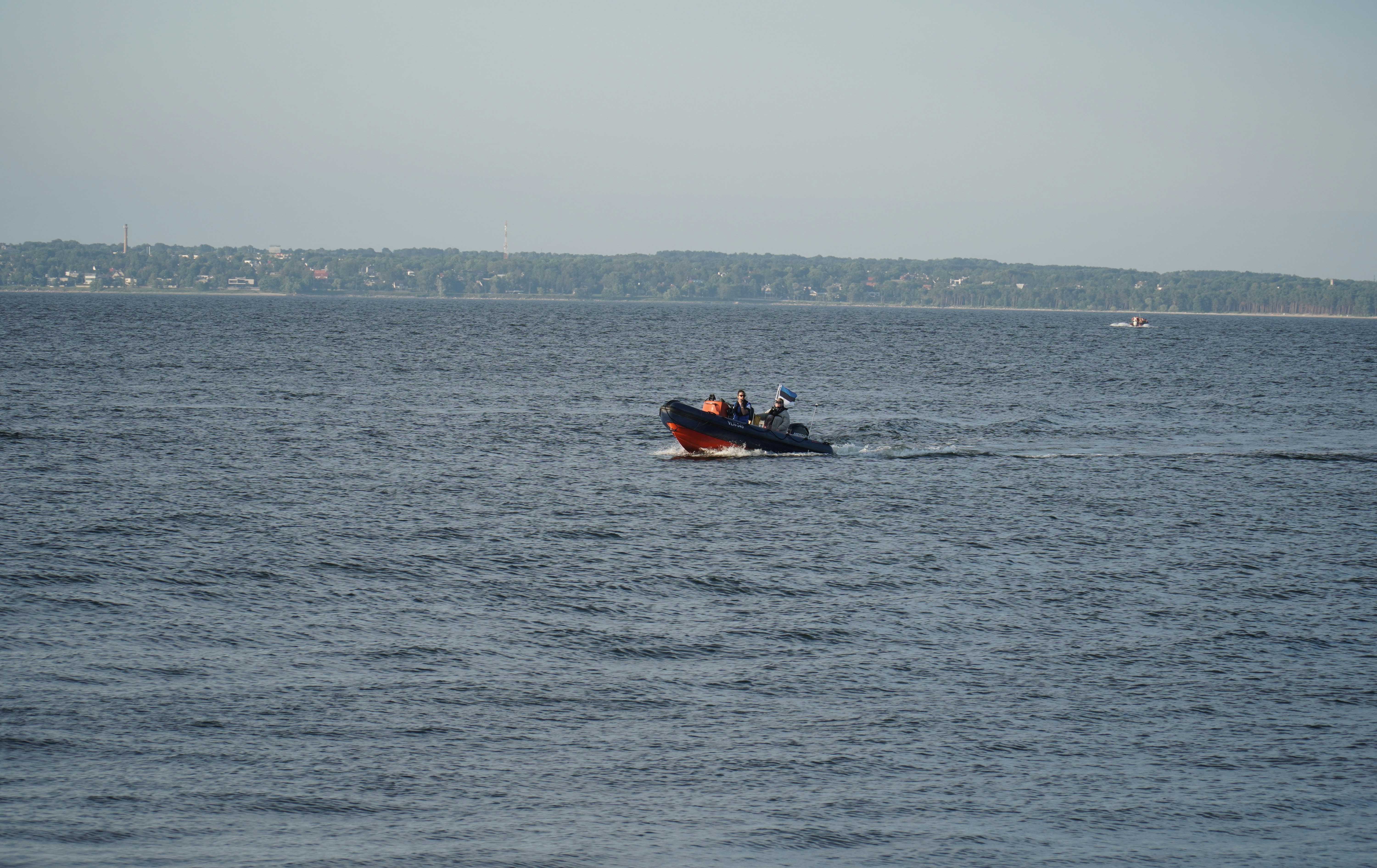 A small boat in the middle of a large body of water