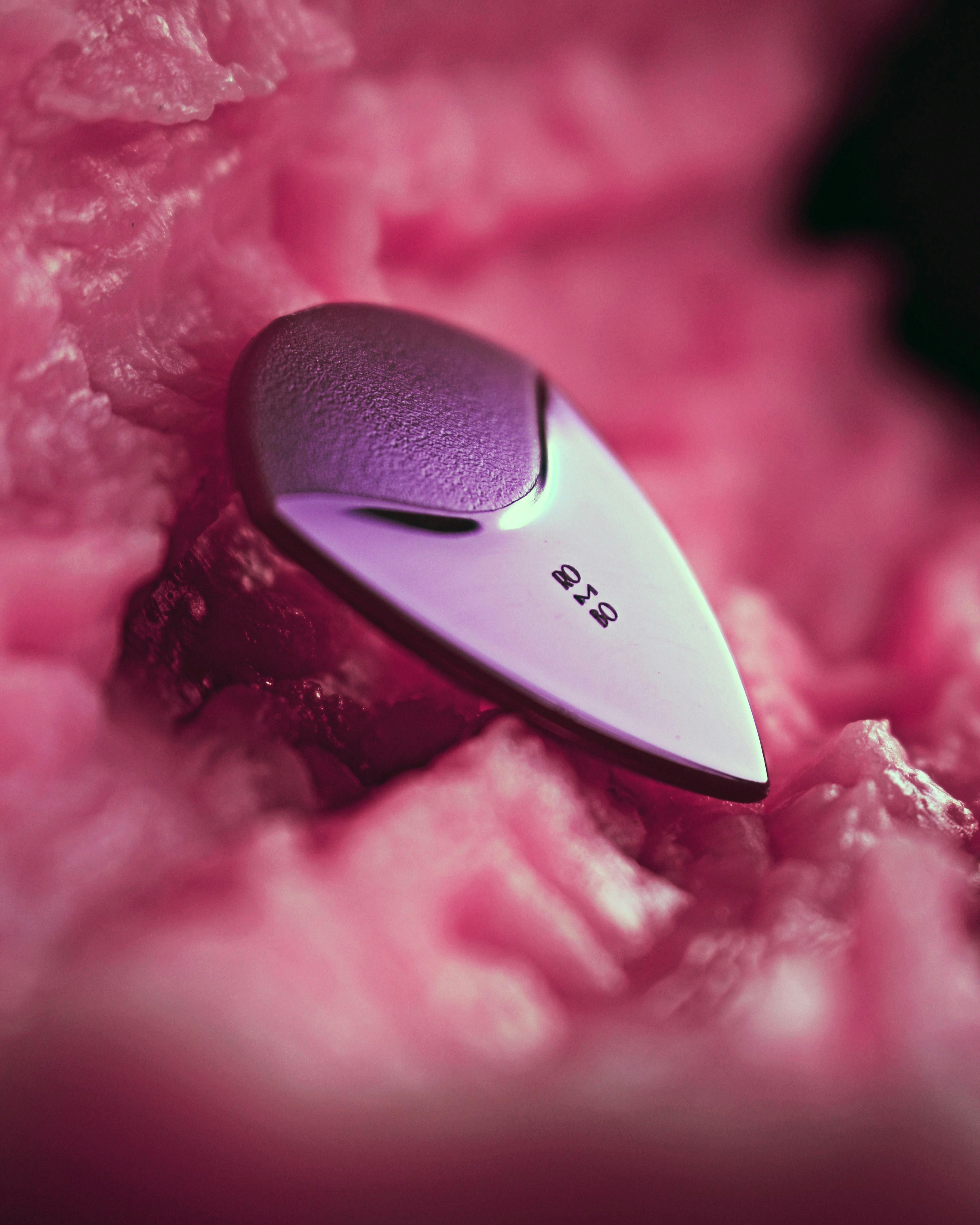 A purple and silver object on a pink blanket