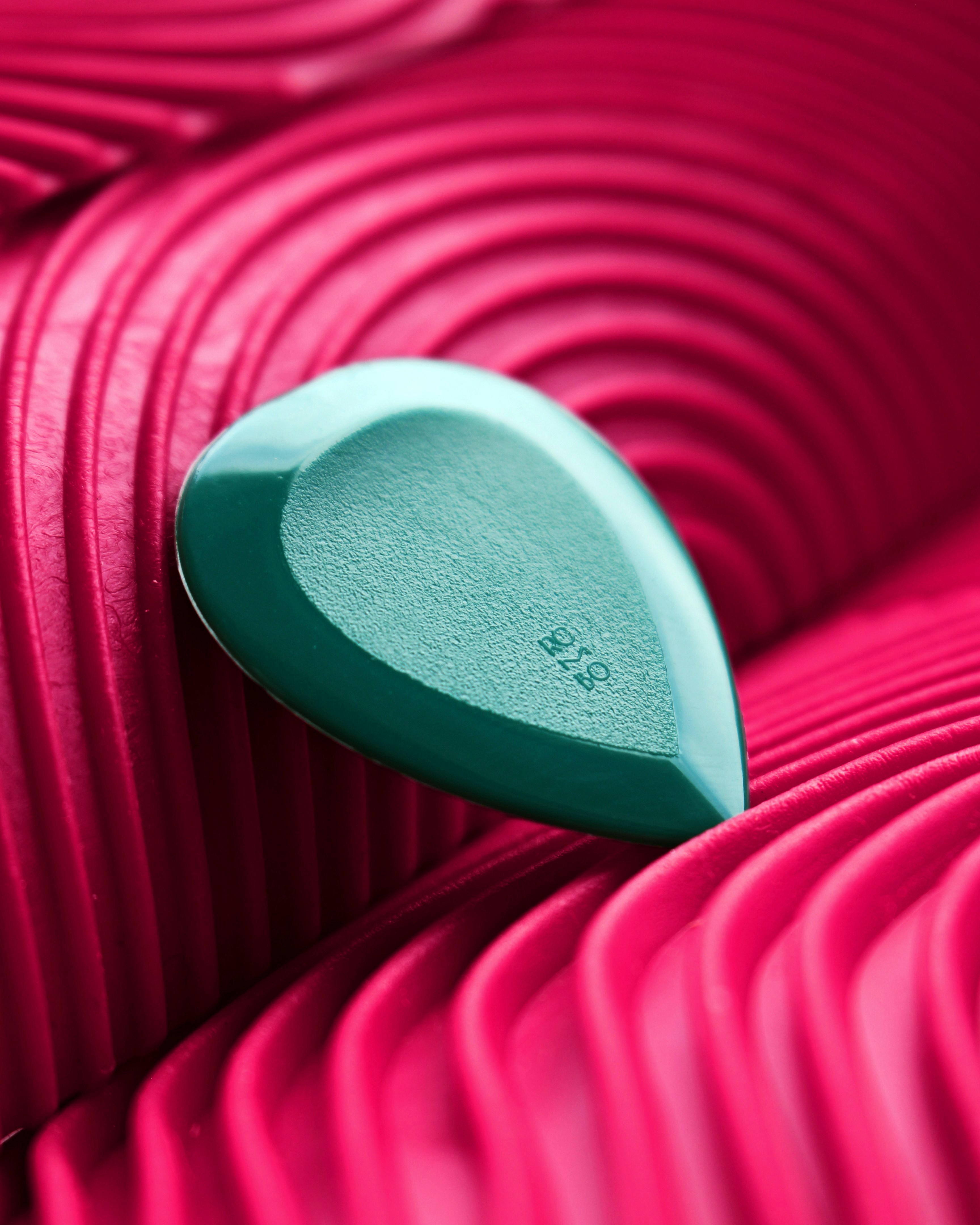 A heart shaped object sitting on top of a pink surface