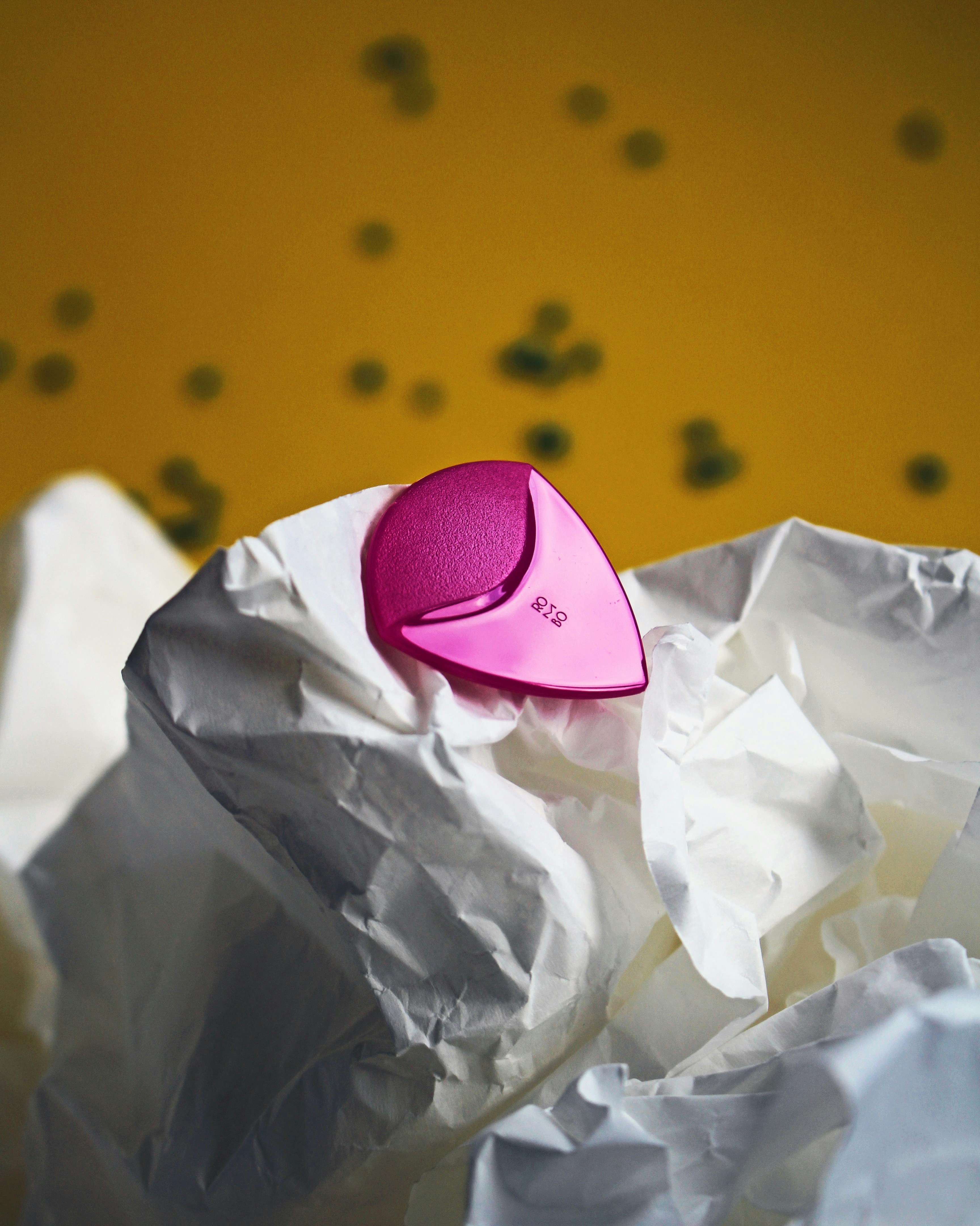 A pink hair brush sitting on top of a pile of crumpled paper