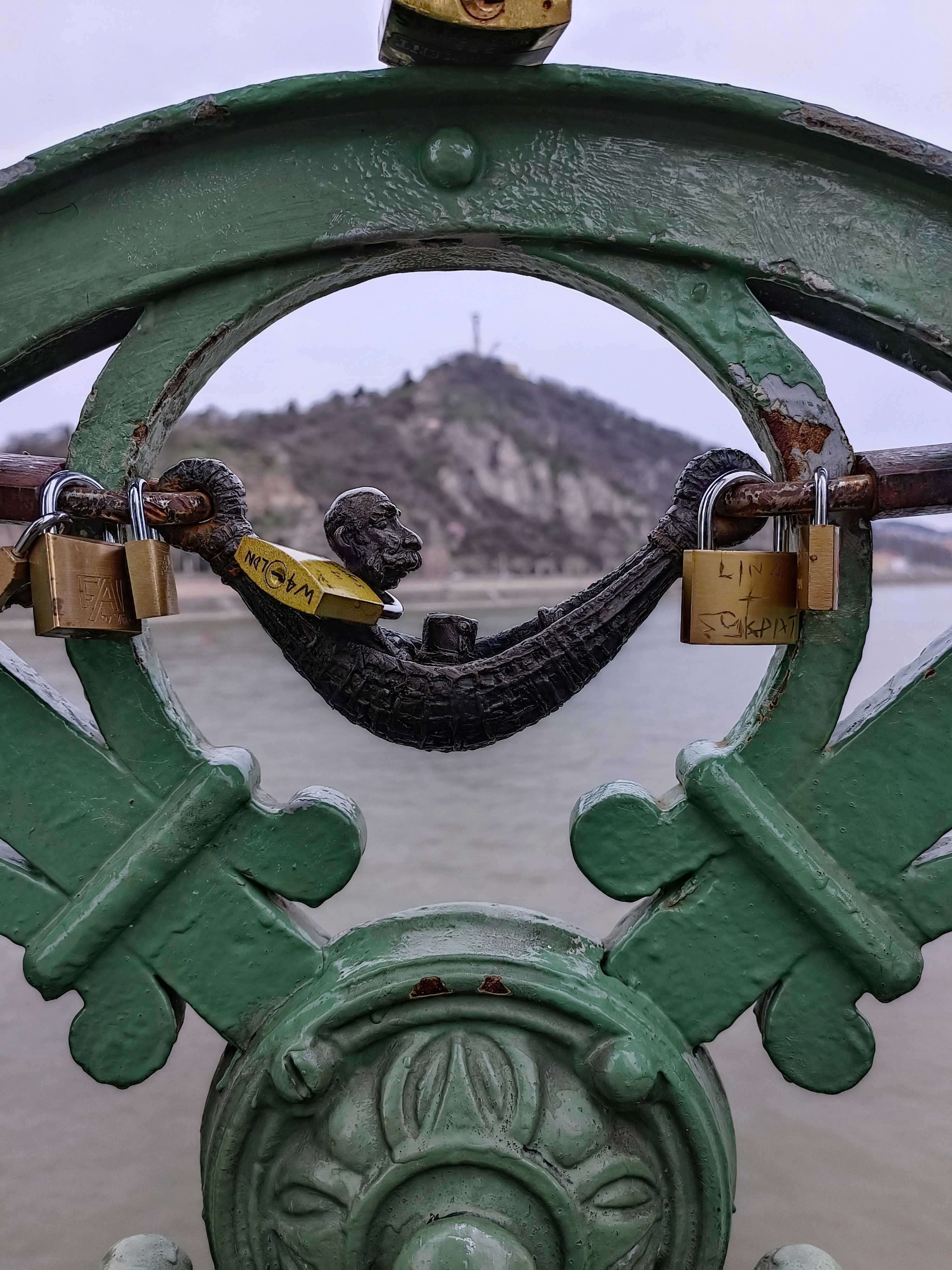 A close up of a metal gate with a bird on it