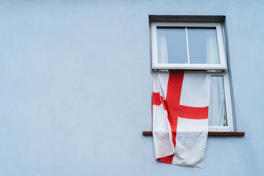 A red and white flag hanging from a window