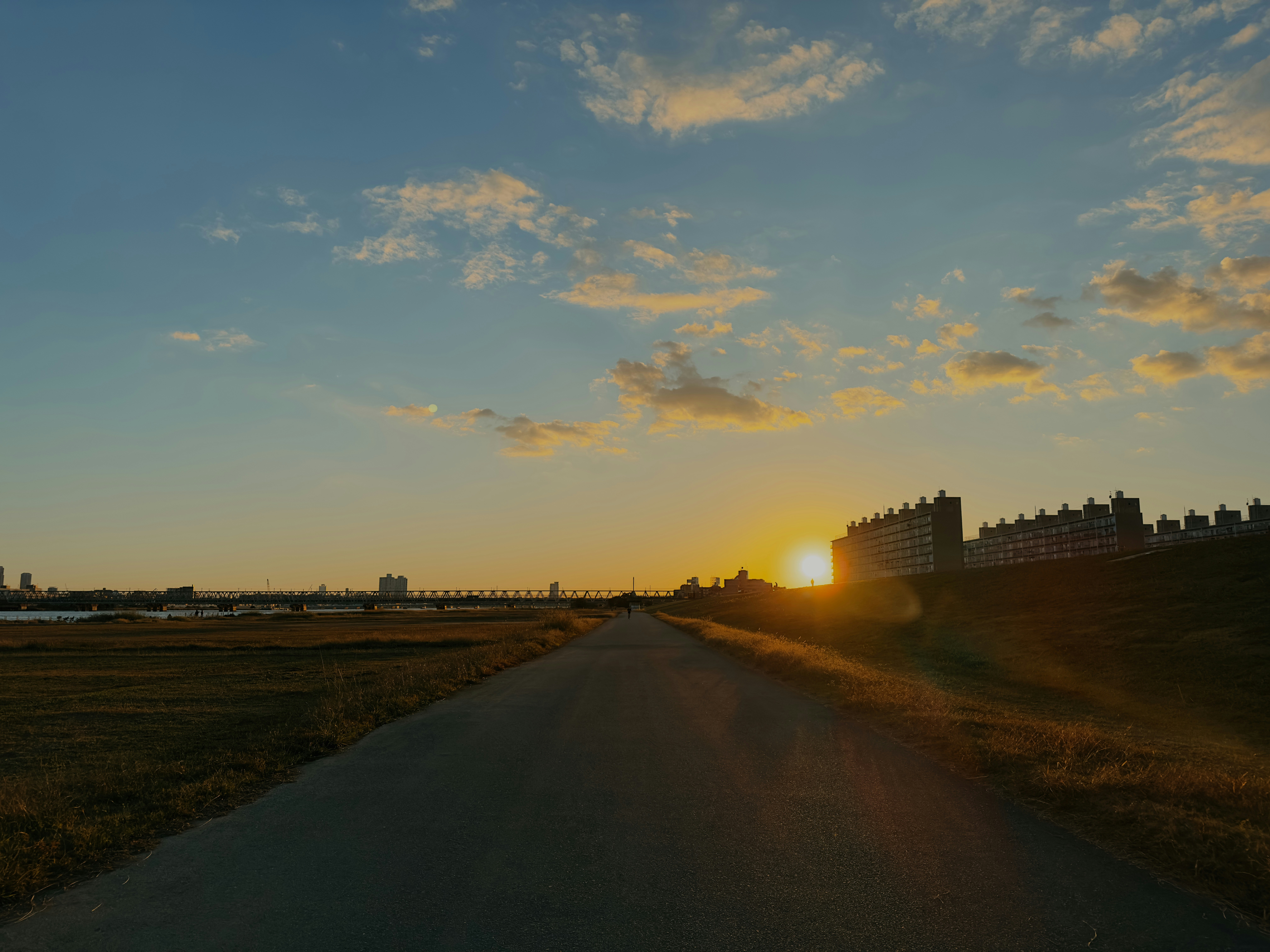 The sun is setting over a road with a castle in the background