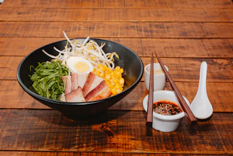 A wooden table topped with a bowl of food