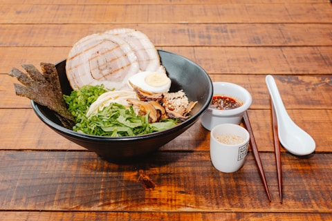 A wooden table topped with a bowl of food