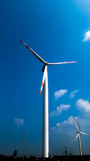 A wind turbine is shown against a blue sky