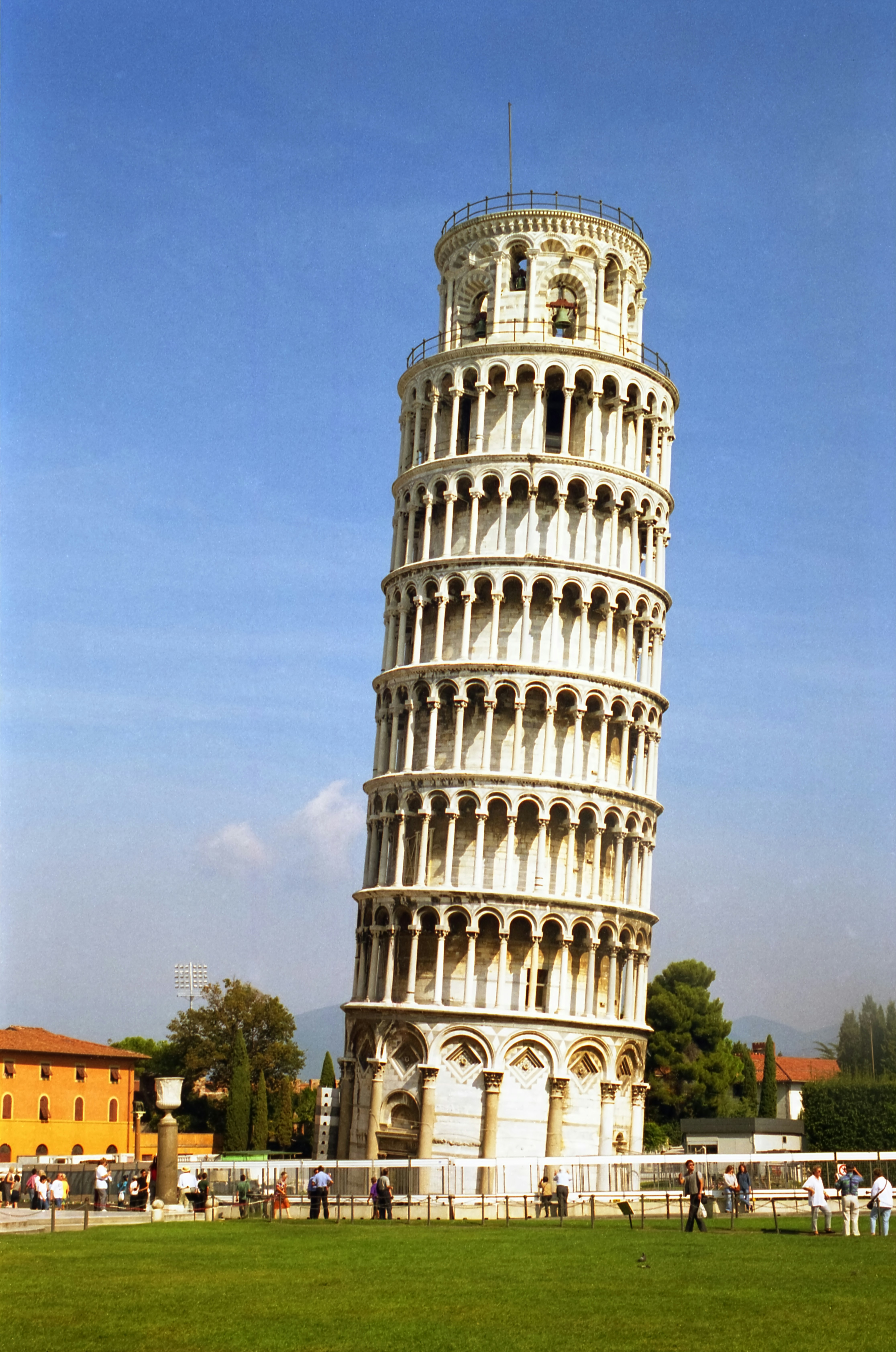 A tall white tower sitting in the middle of a lush green field