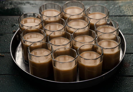 A metal tray filled with glasses filled with liquid