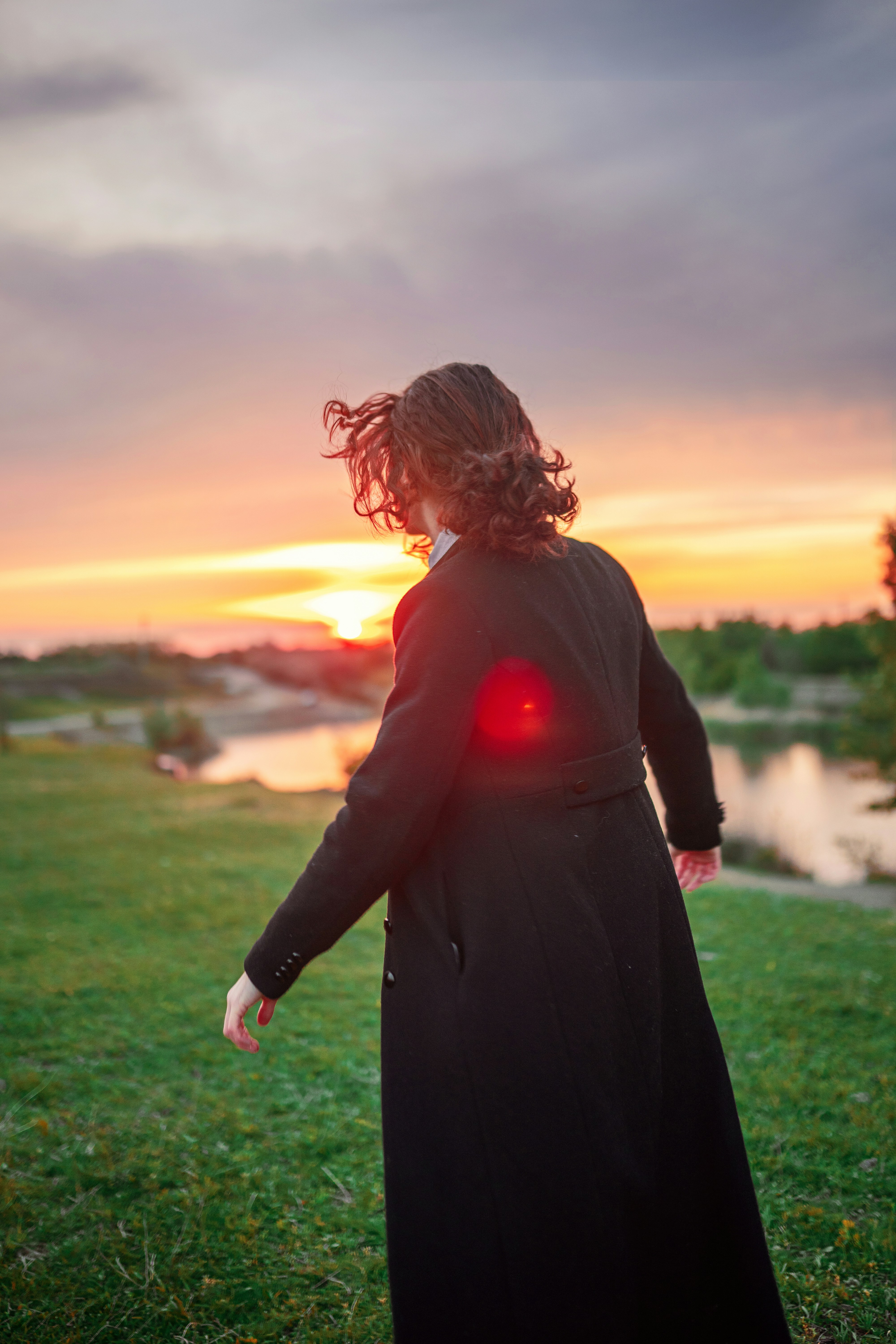 Uma mulher em pé em um campo com uma luz vermelha na mão