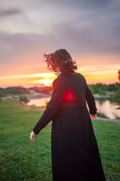 A woman standing in a field with a red light in her hand
