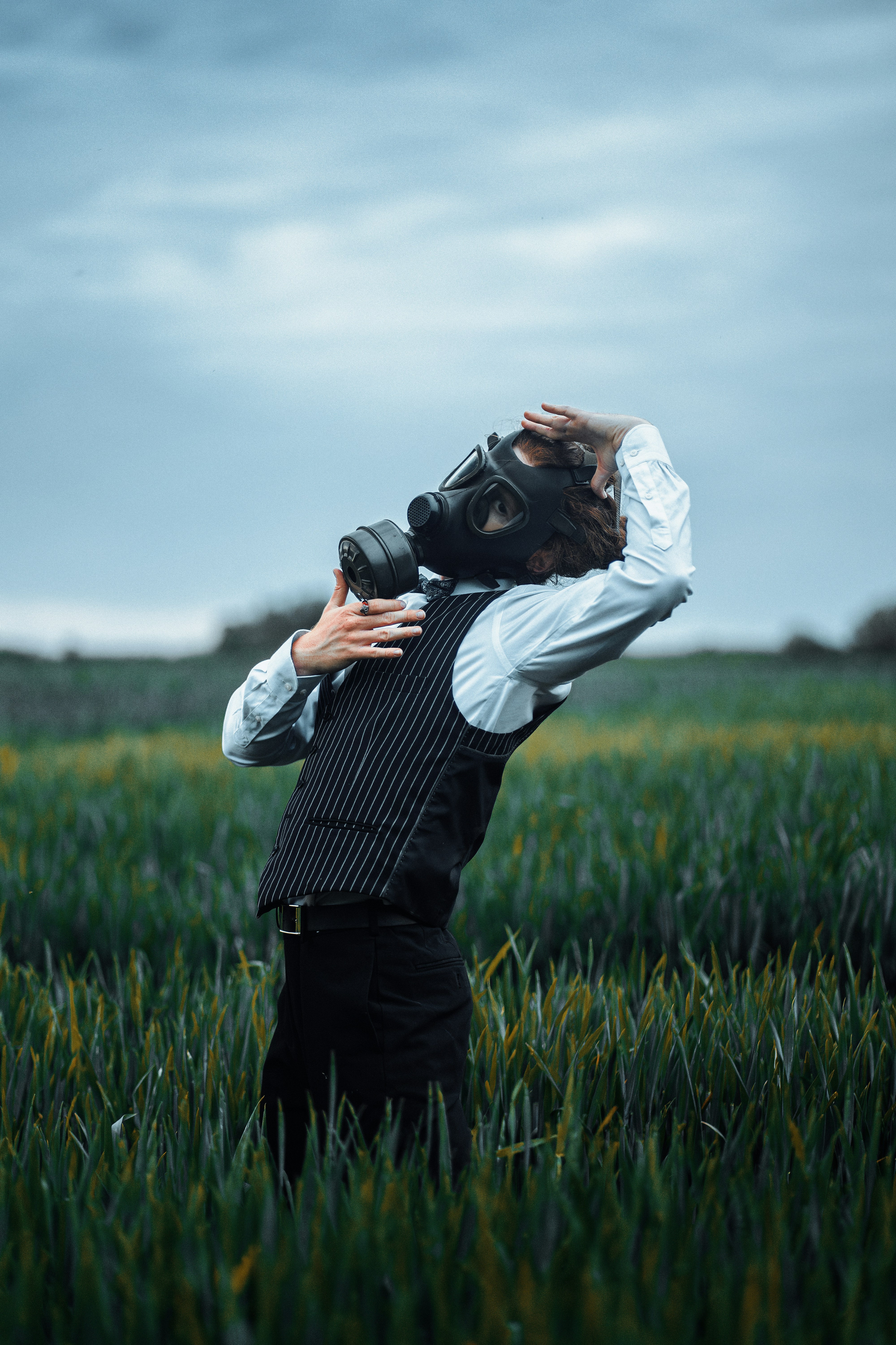 A man standing in a field holding a camera