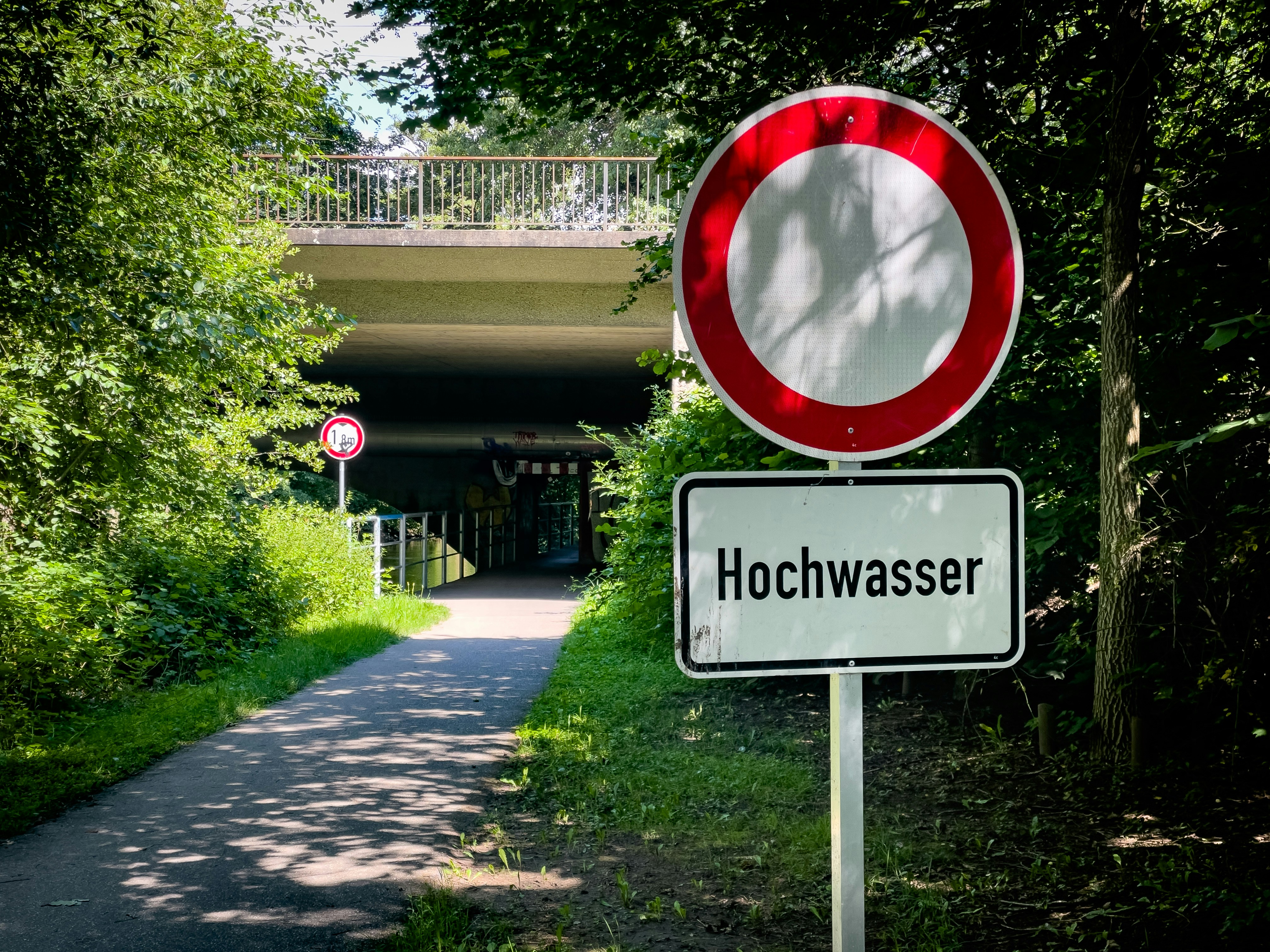A red and white sign sitting on the side of a road
