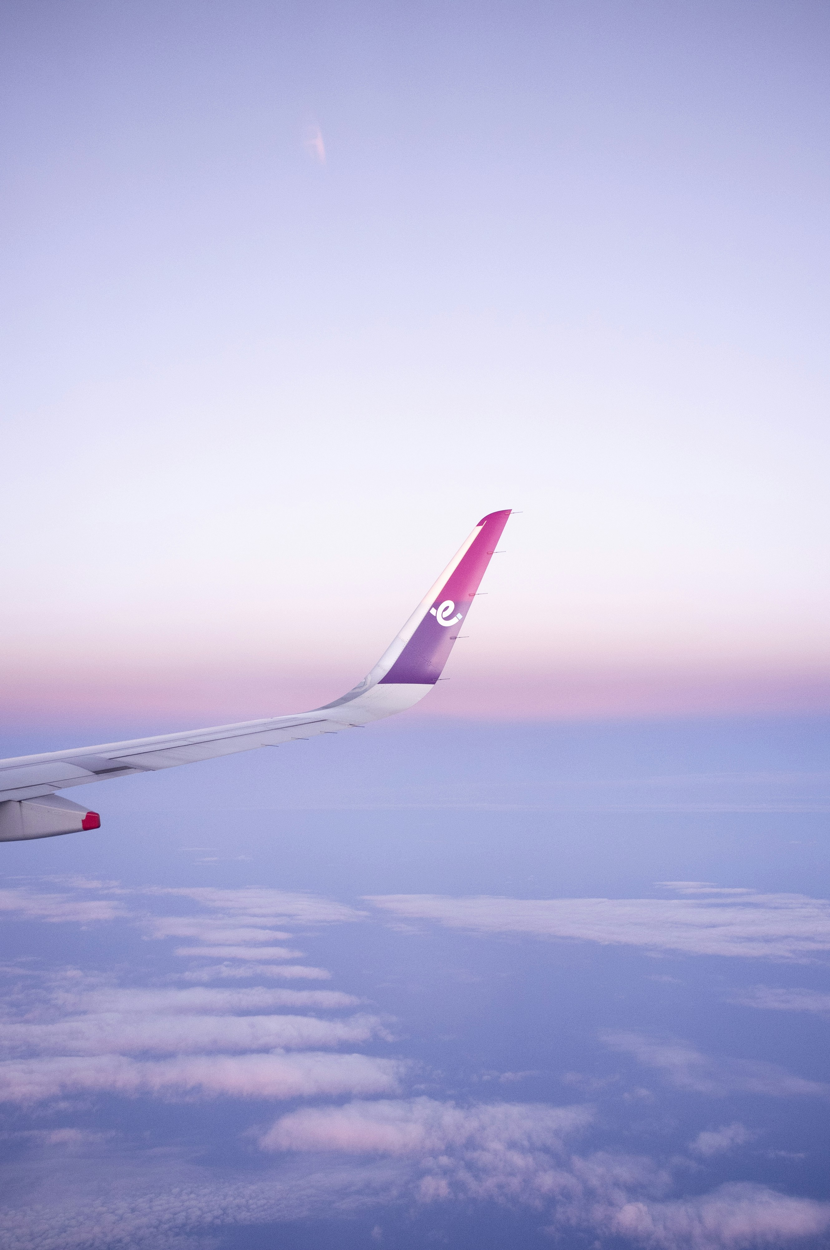 A view of the香港エクスプレスの機内食を利用して快適なフライトを楽しもう wing of an airplane in the sky Via Unsplash (by james chan)