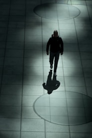 A man walking down a sidewalk at night