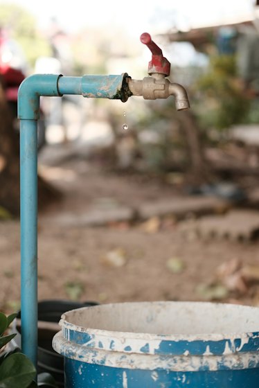 Water dripping from a leaking outdoor pipe