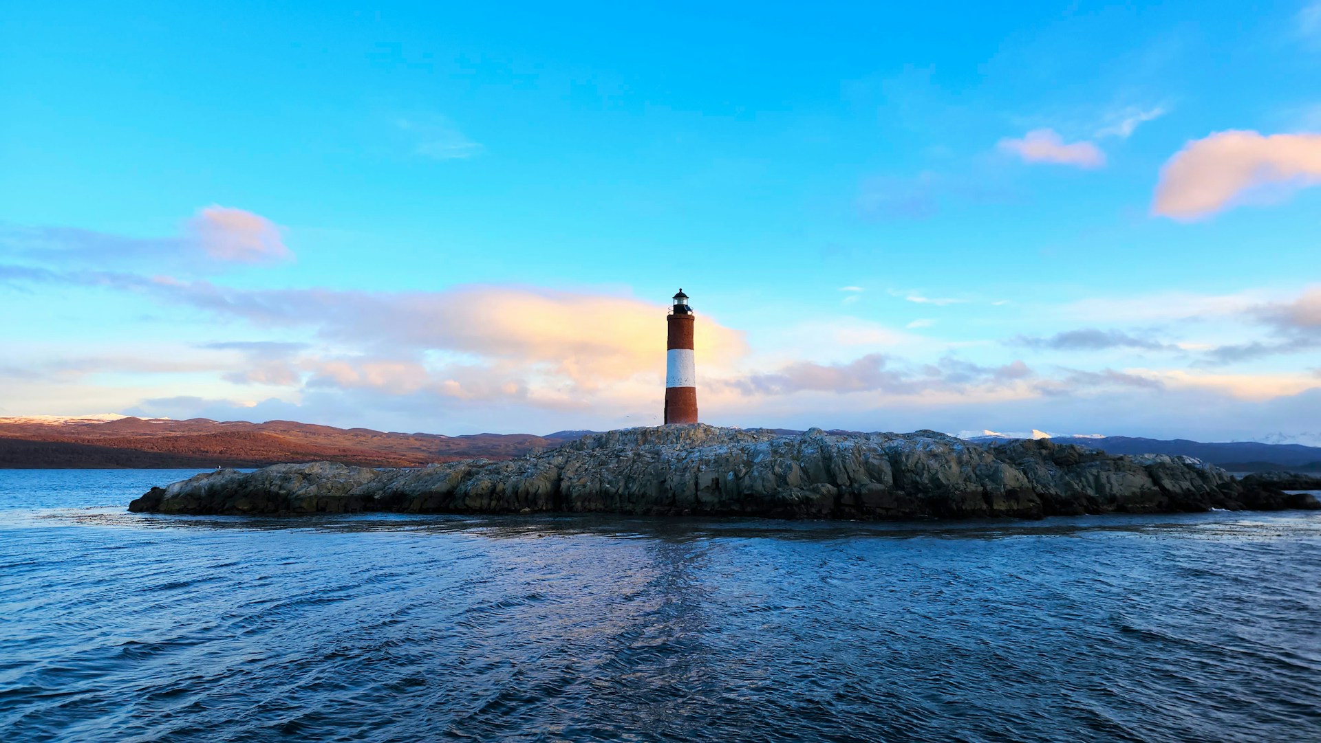 A small light house sitting on top of a small island