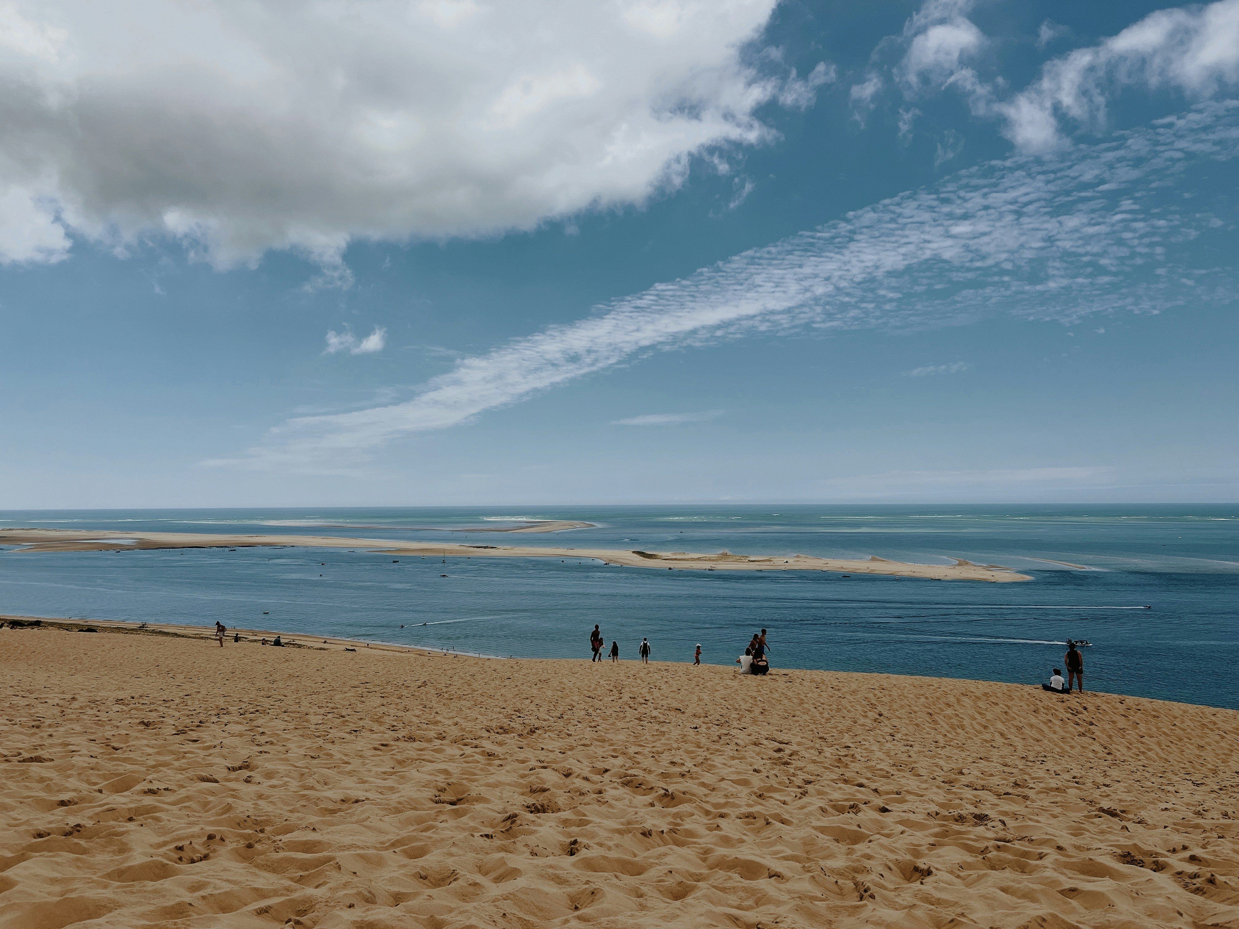 Un grupo de personas de pie en la cima de una playa de arena