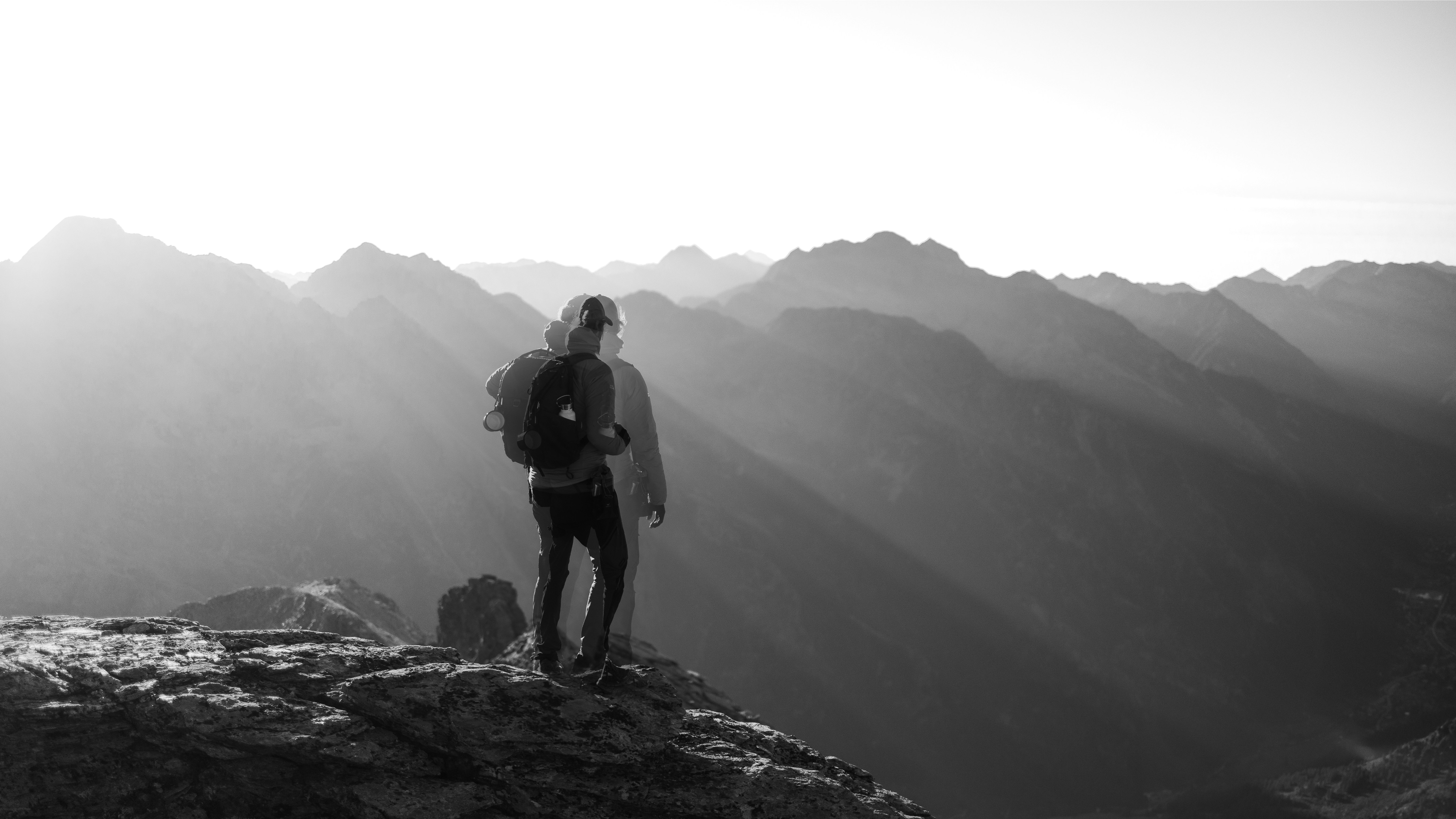 A man standing on top of a mountain with a backpack