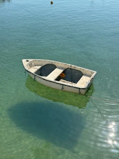 A small boat floating on top of a body of water