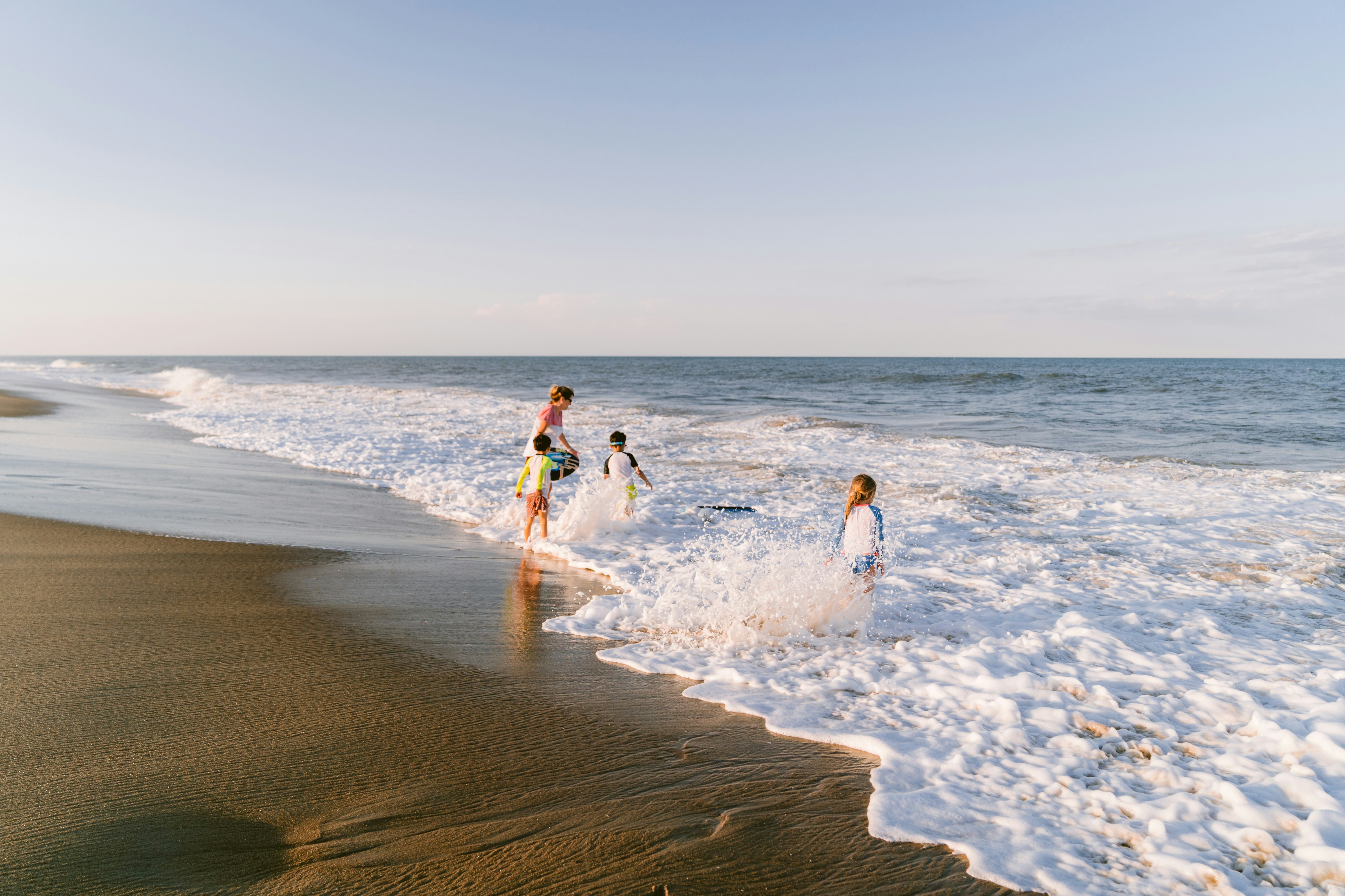 A group of people standing on top of a sandy beach