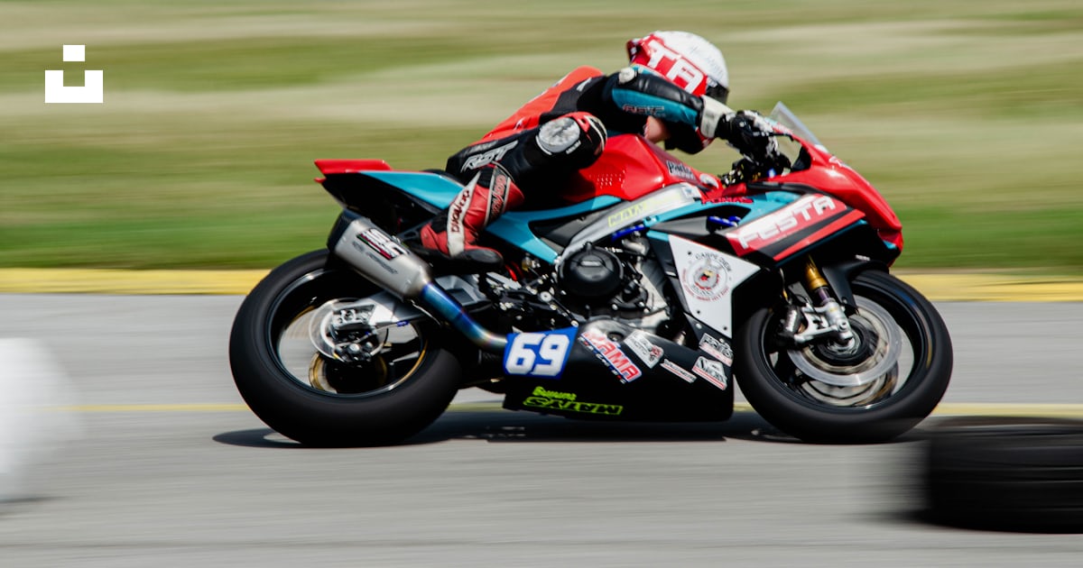 A person riding a motorcycle on a race track photo – Free Ducati Image ...