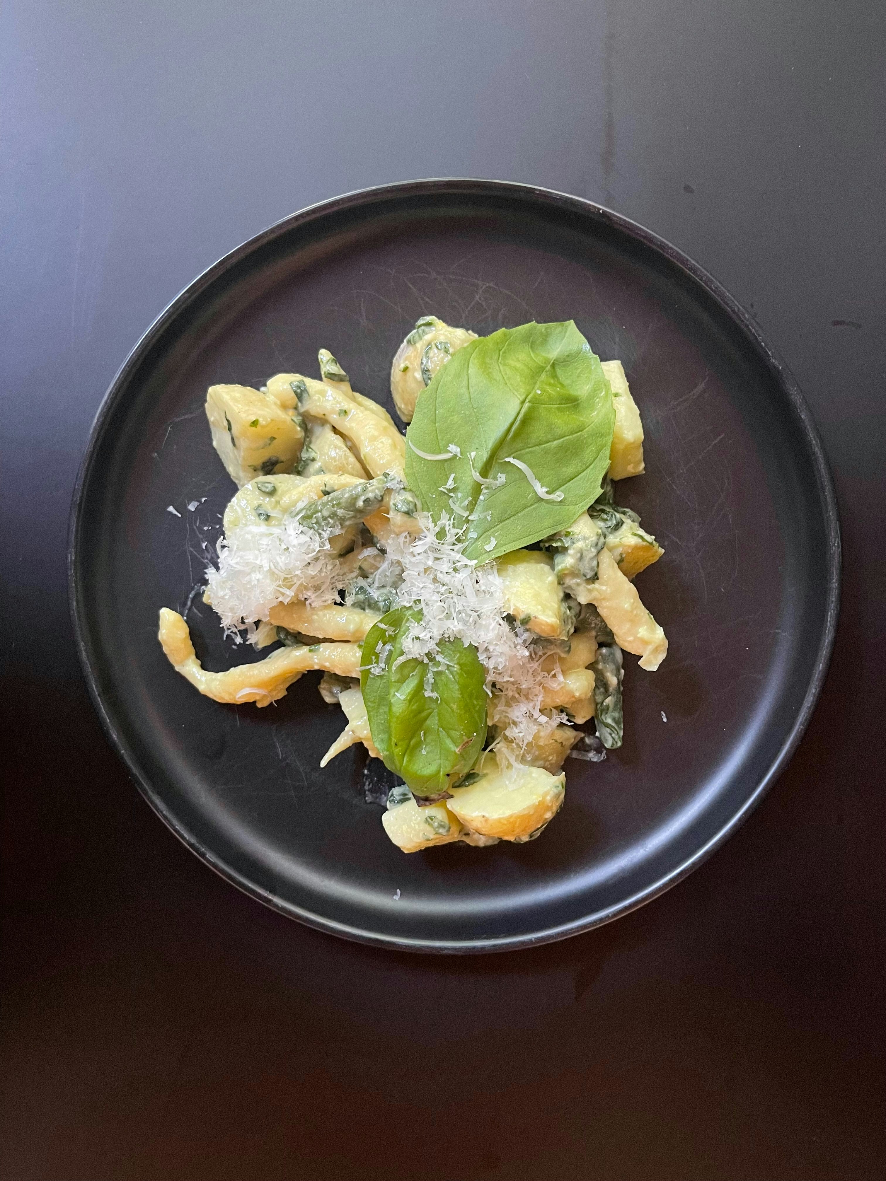 A plate of pasta with spinach and parmesan cheese
