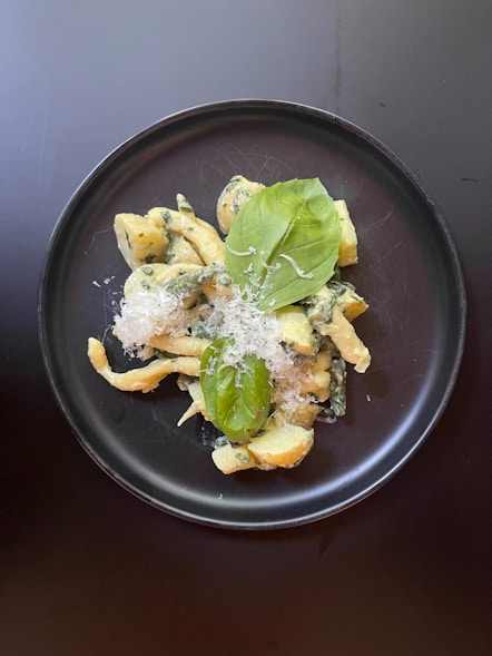 A plate of pasta with spinach and parmesan cheese