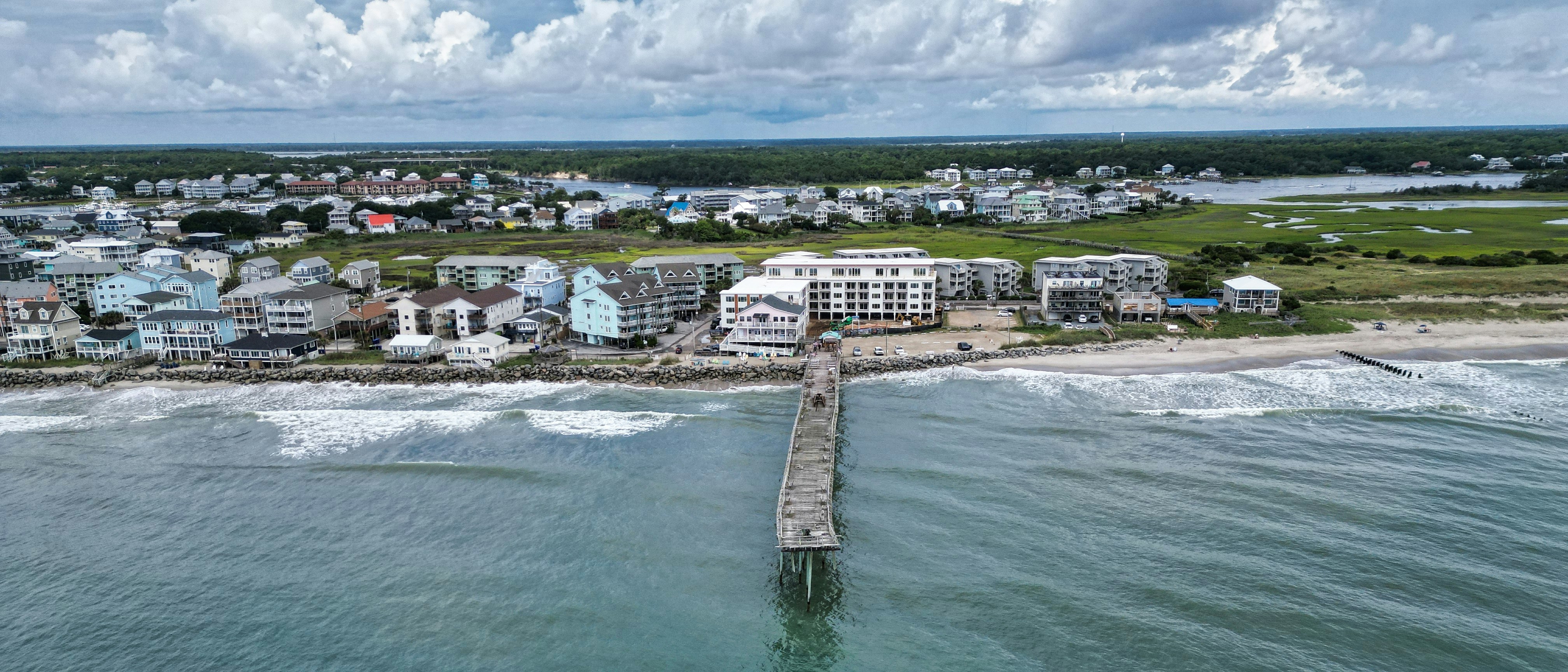 An aerial view of a beach town with a pier
