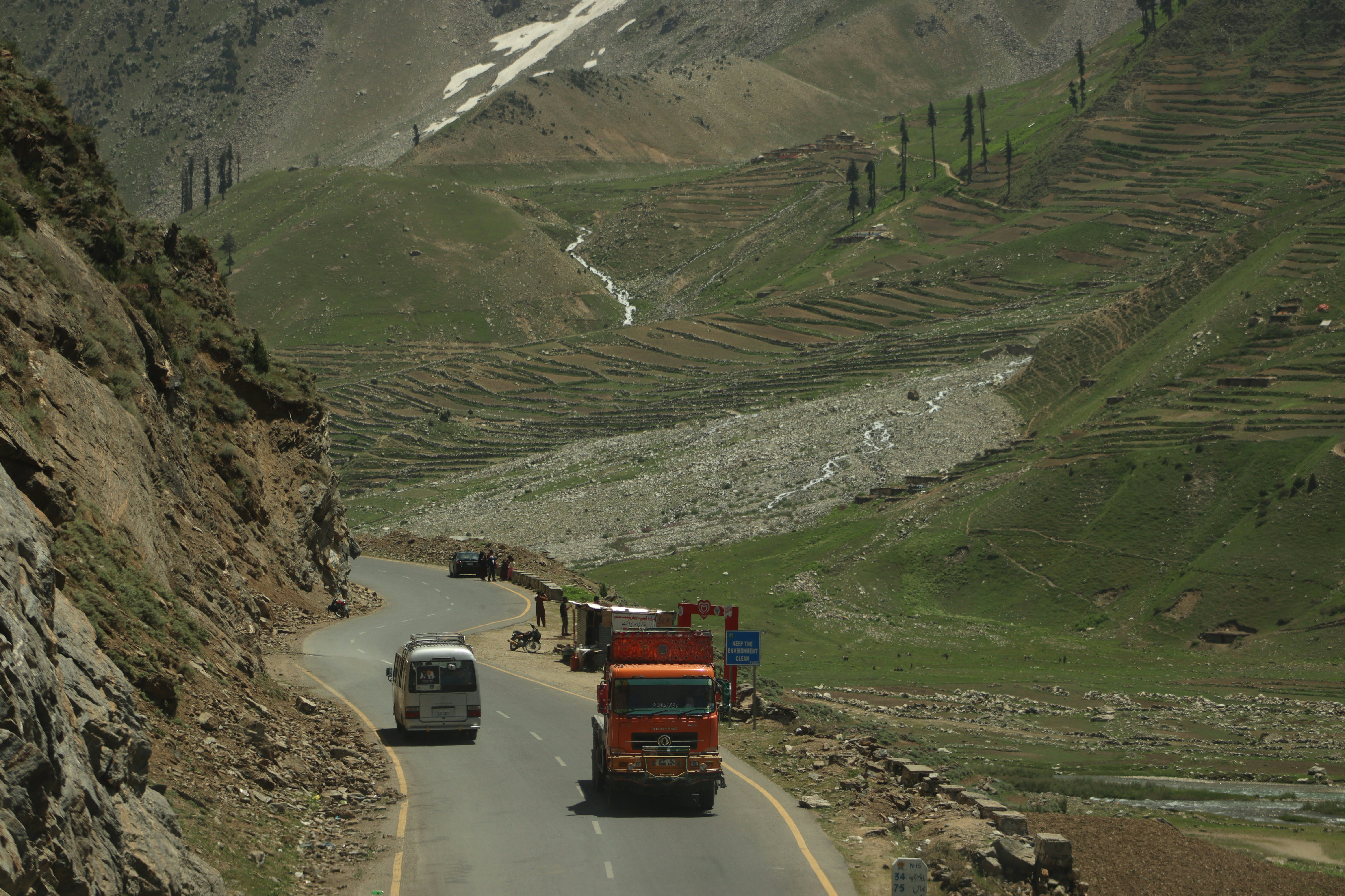 A couple of trucks driving down a mountain road