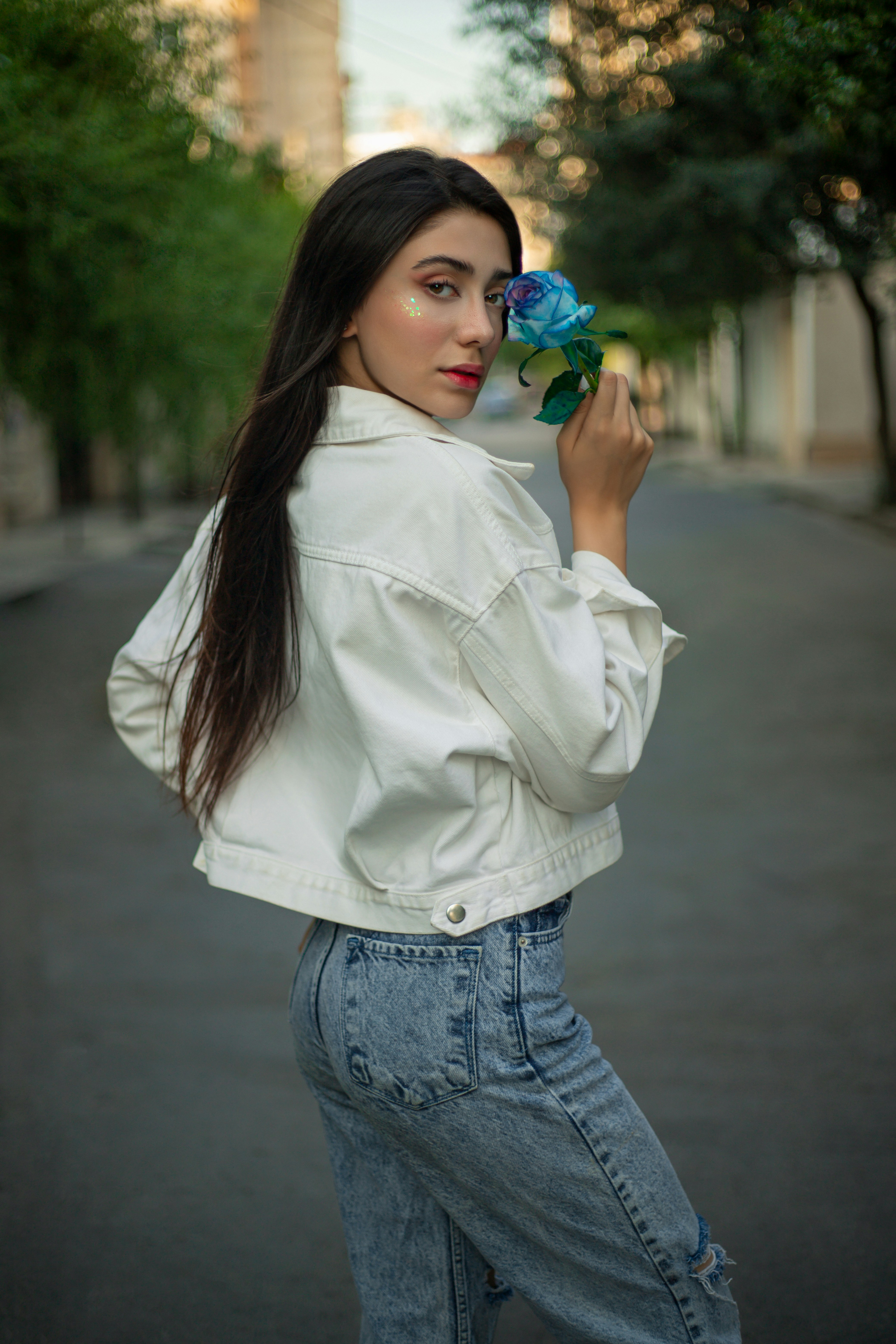A woman in a white jacket holding a flower