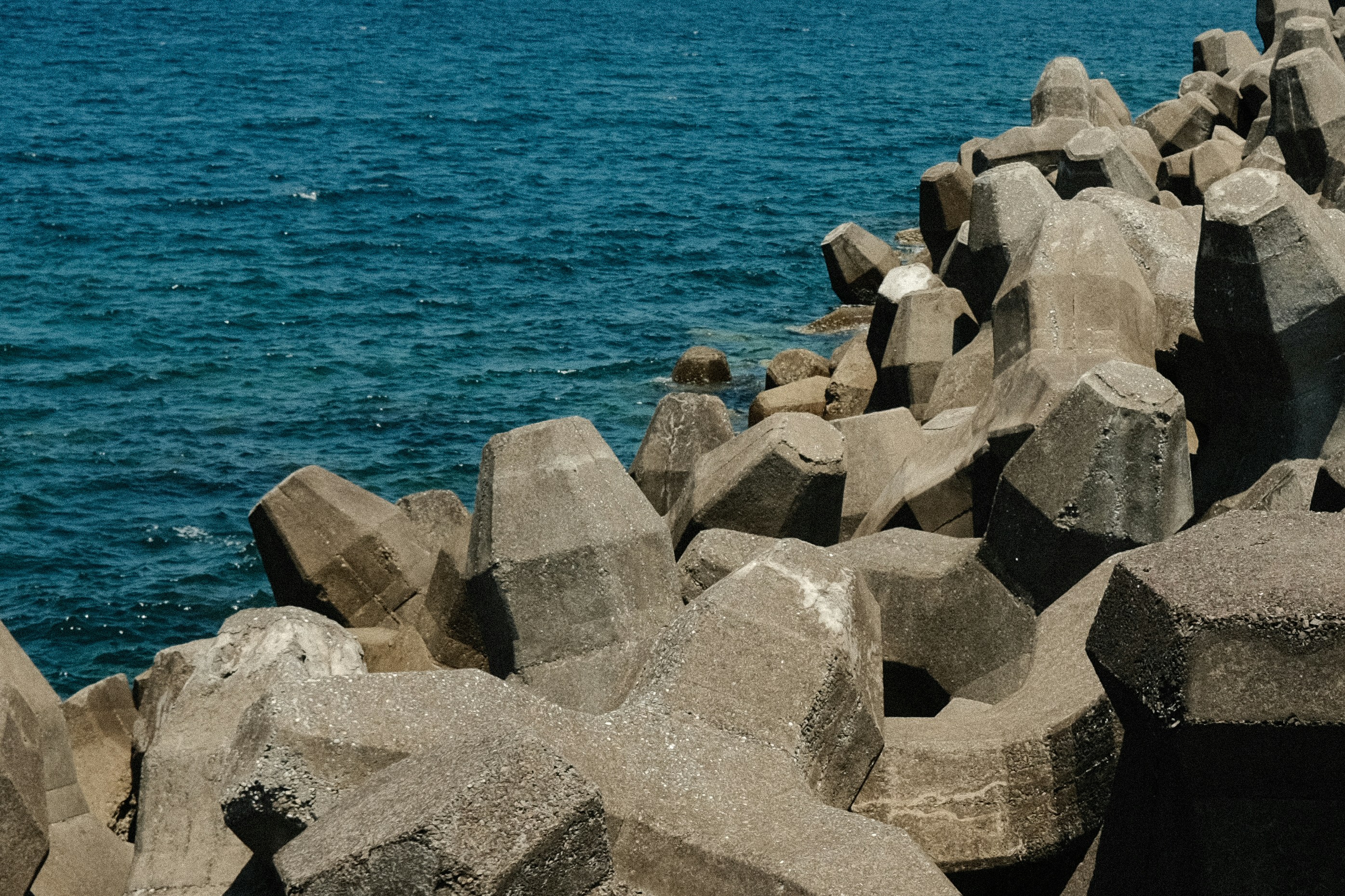 A large body of water sitting next to a rocky shore