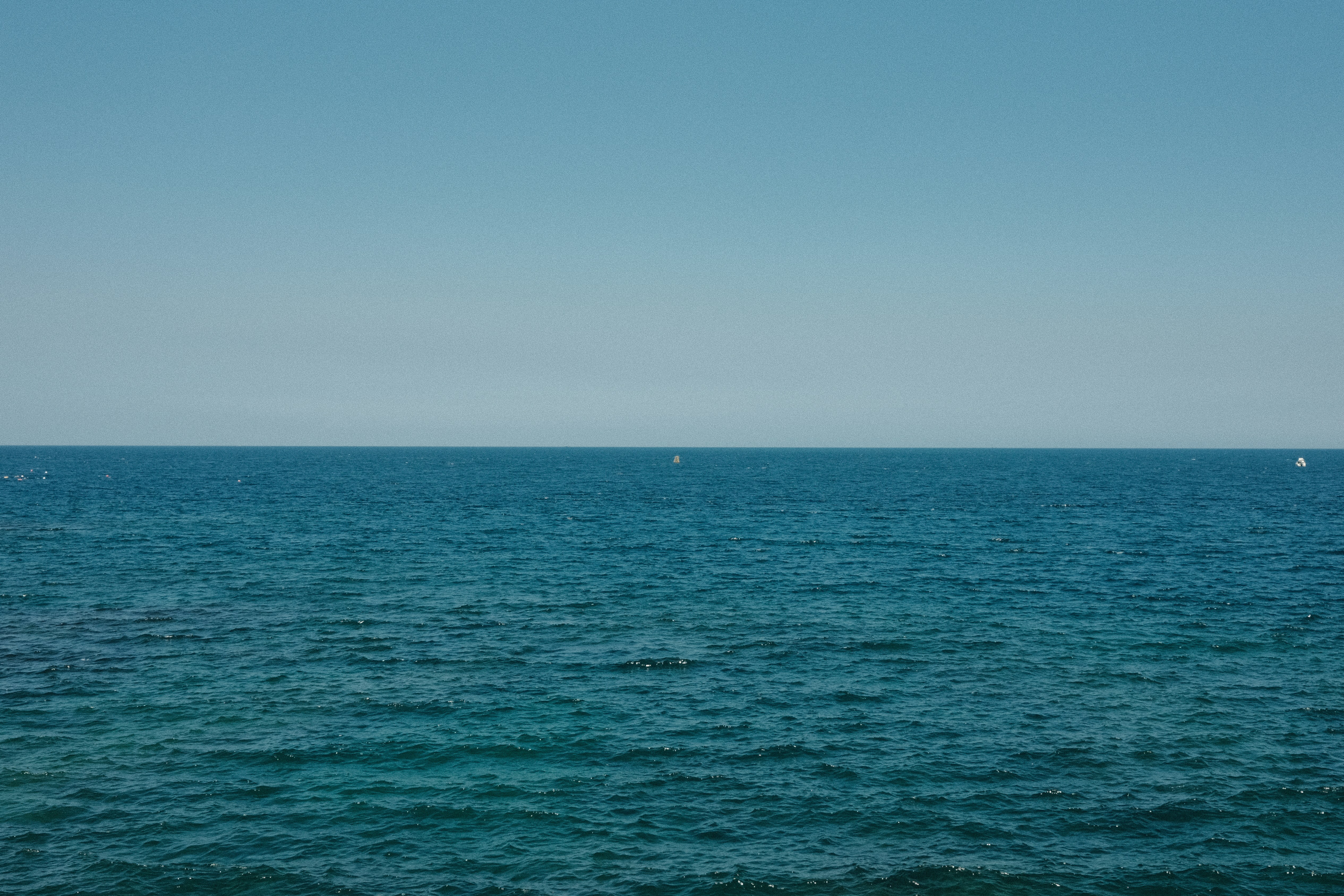 A large body of water sitting under a blue sky