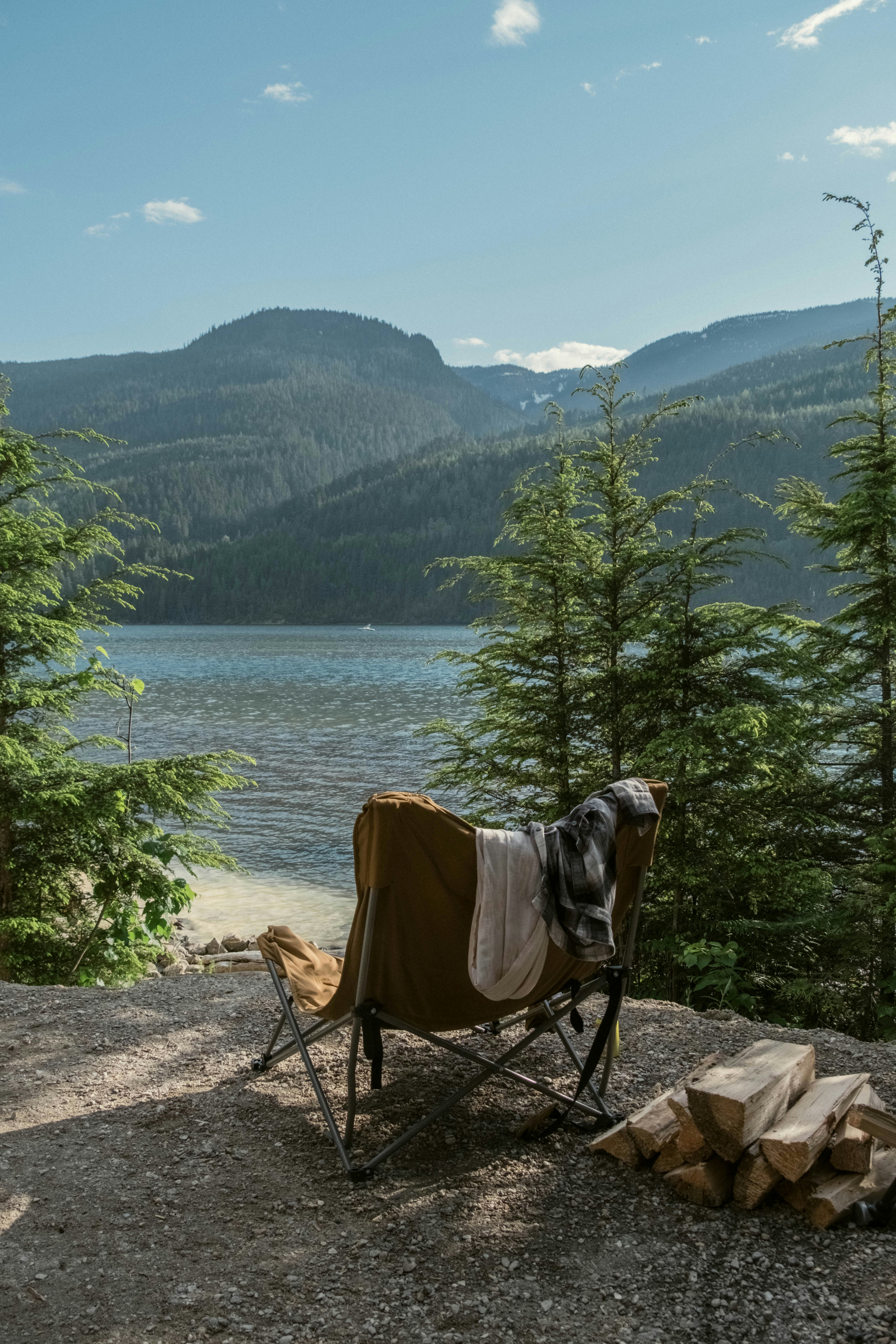 Una sedia da campeggio con una coperta sopra vicino a un lago