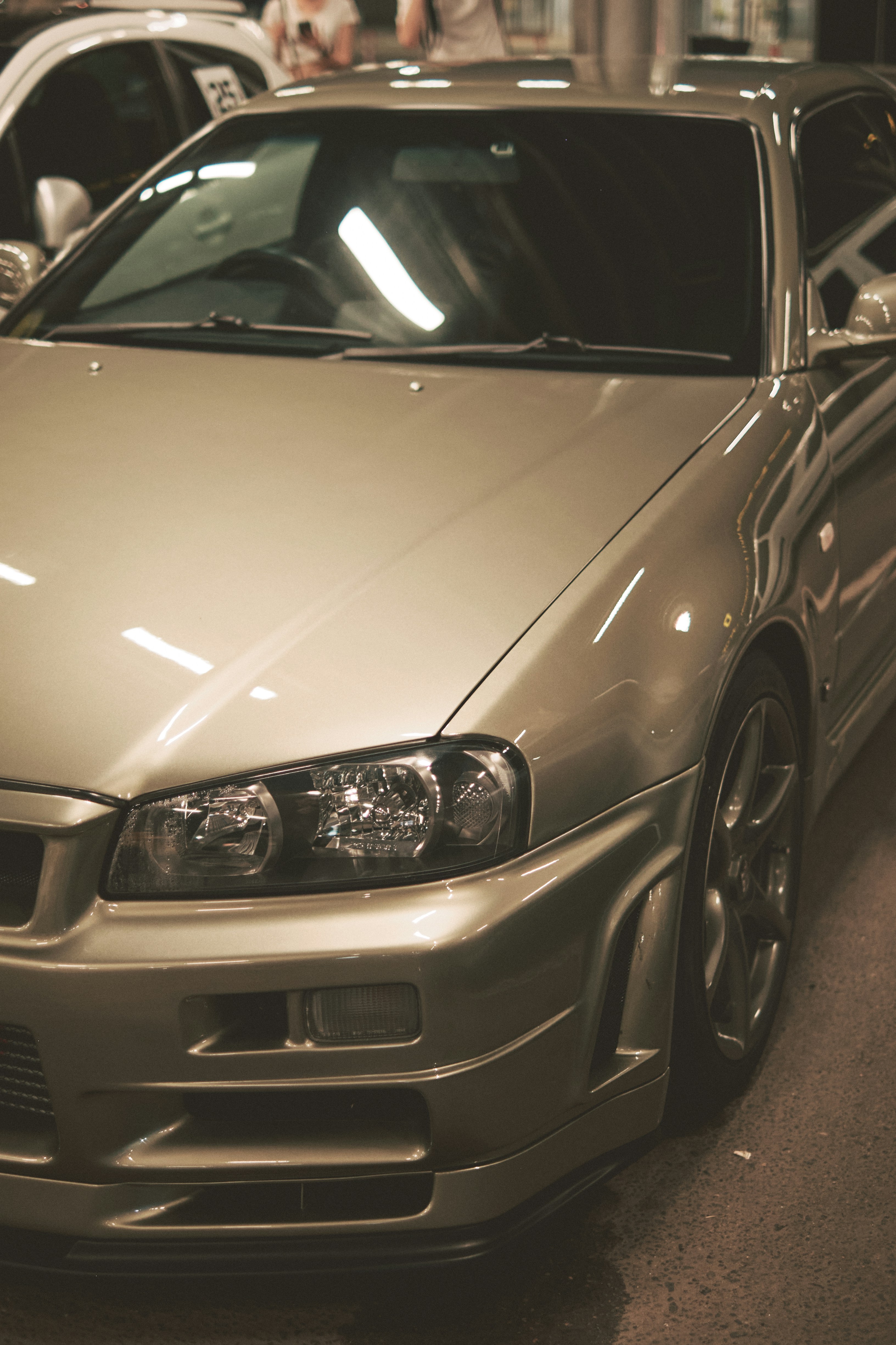 A silver car parked in a garage next to other cars