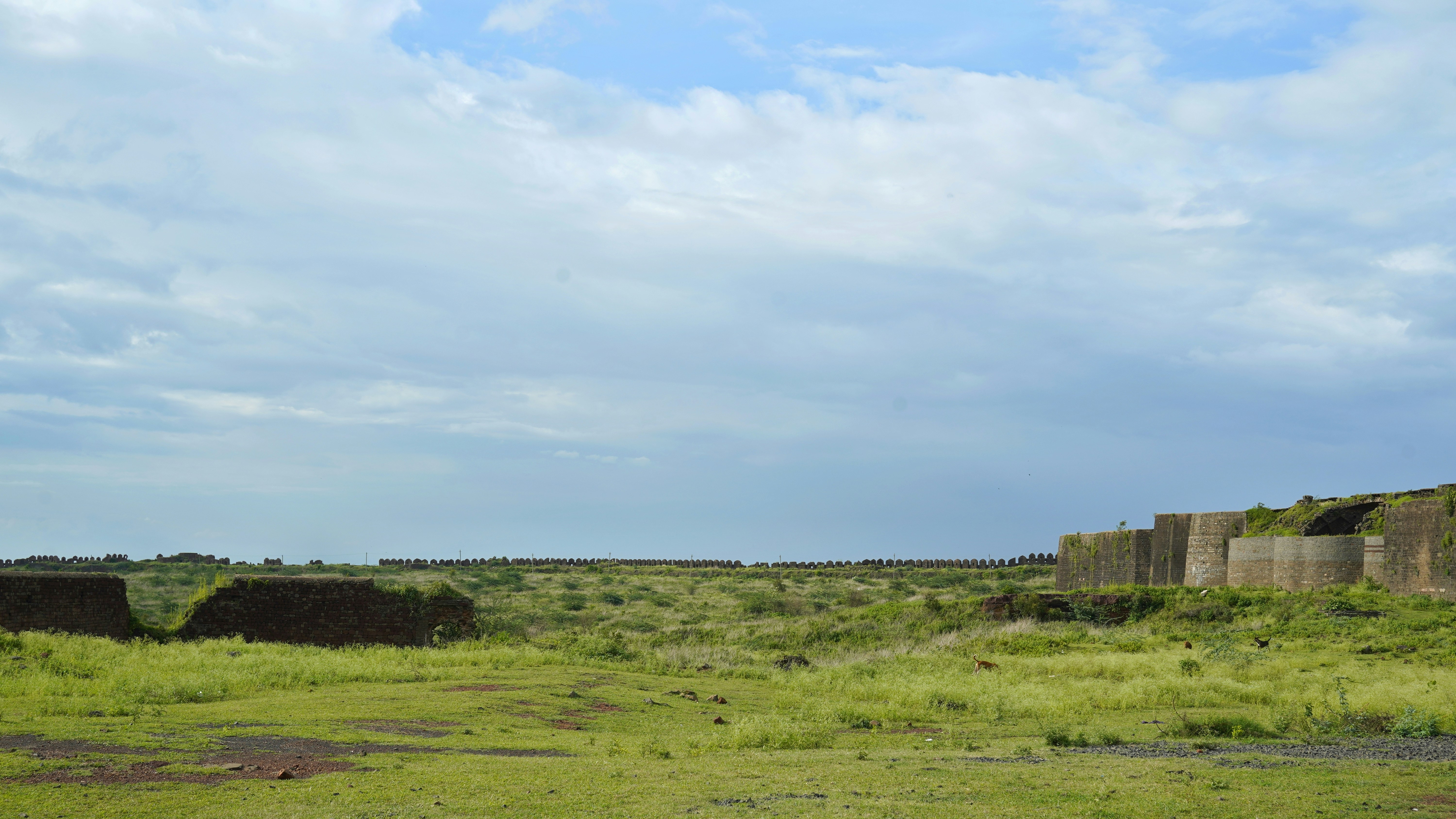 Ancient stone fort ruins on hilltop with panoramic views of Karnataka countryside