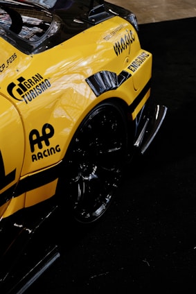 A yellow sports car with a racing sticker on it's side