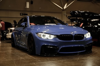 A blue car parked in a garage next to other cars